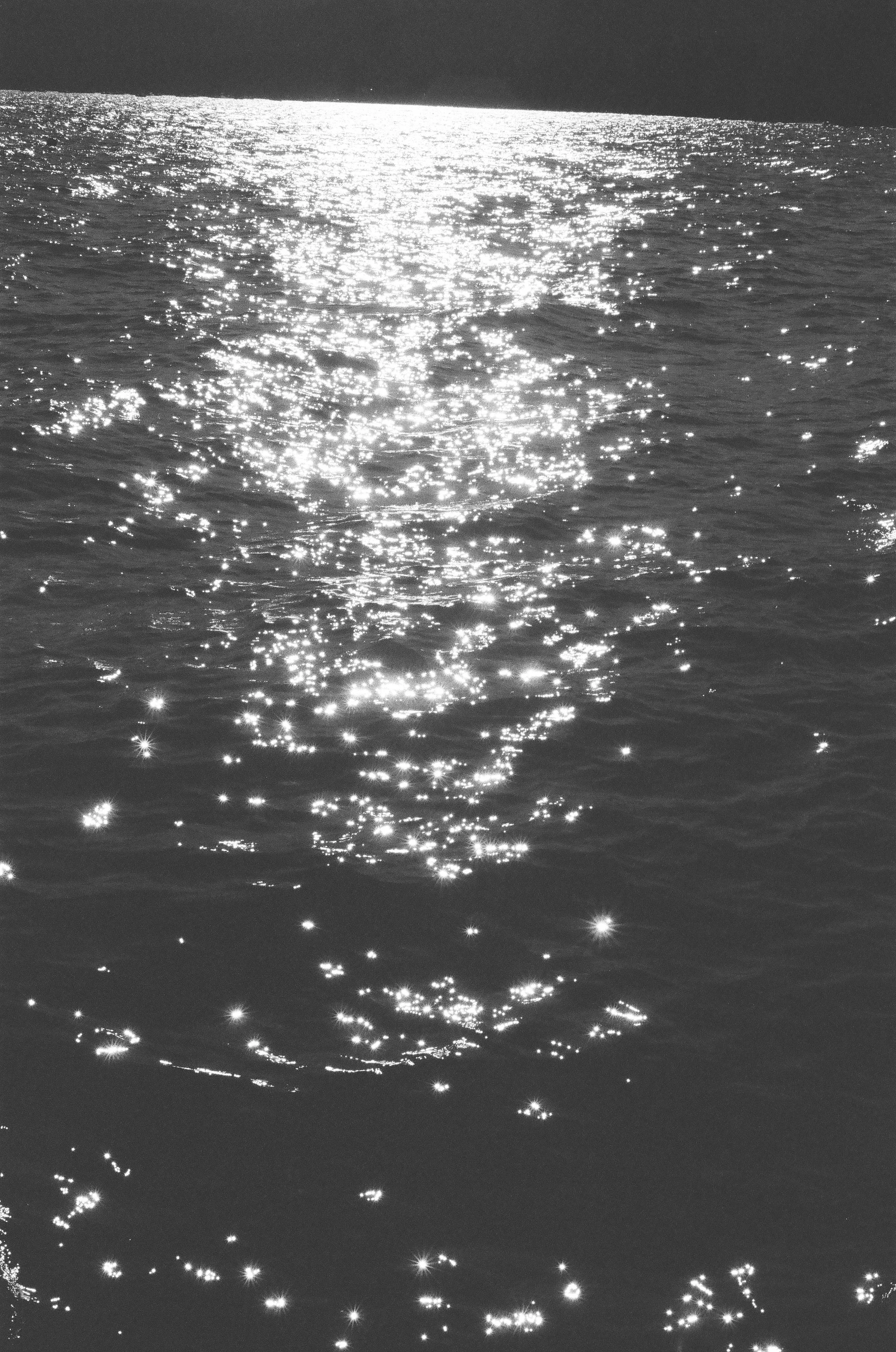 Sunlight reflecting on the surface of a body of water, creating a shimmering effect.