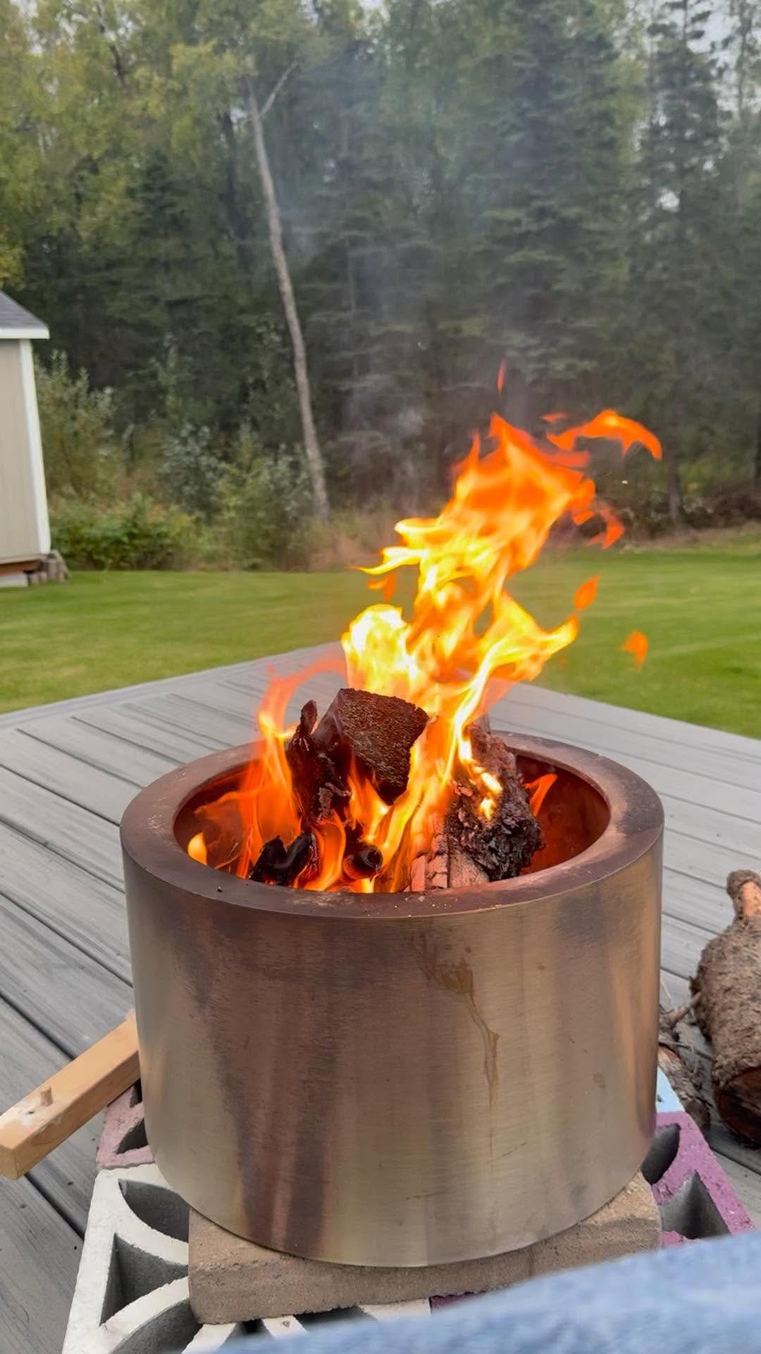 The Shale House firepit burning against the Alaska woods.