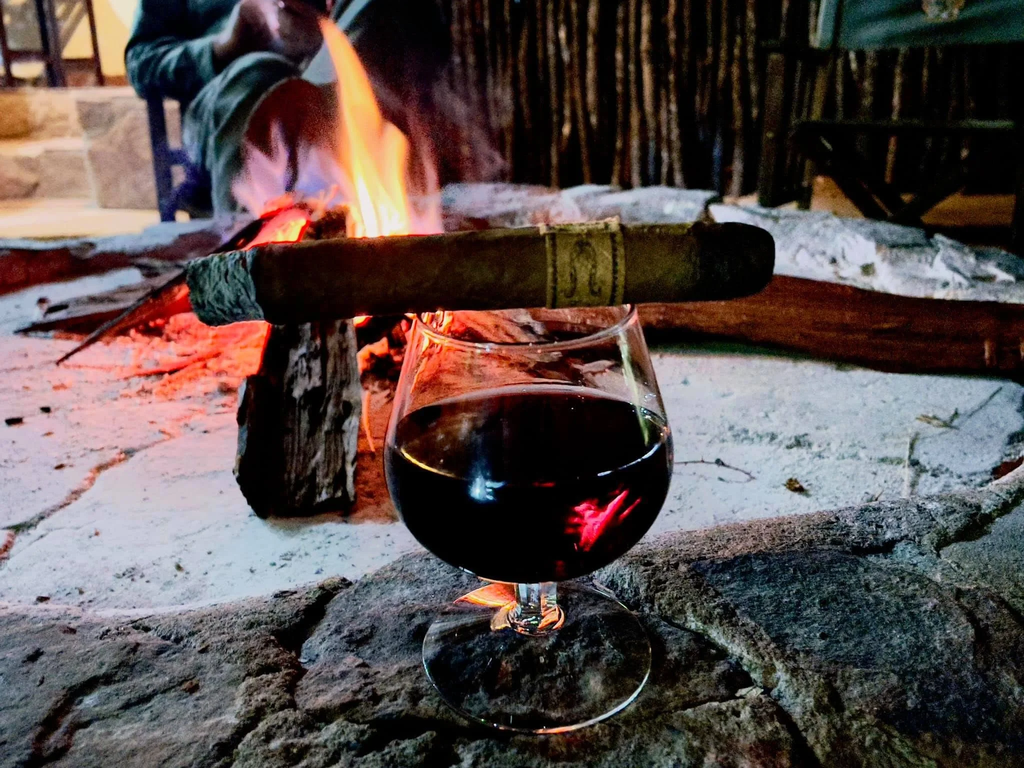 A cigar and glass beside the fire at Kuvhima Safaris.
