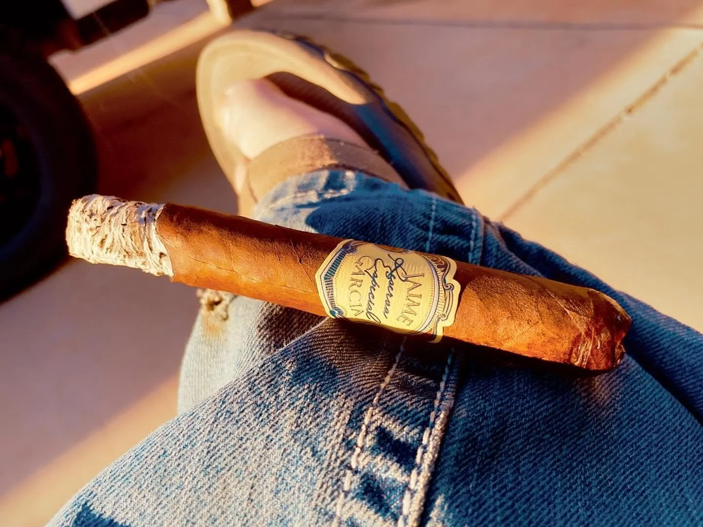 A lit Jaime Garcia cigar resting in the evening sun.