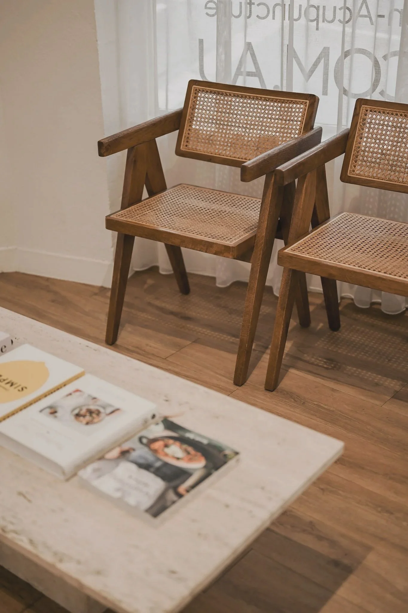 Reception area inside Tonic Co., where Verde Laser Clinic is located, featuring timber chairs, a white side table and soft natural light.