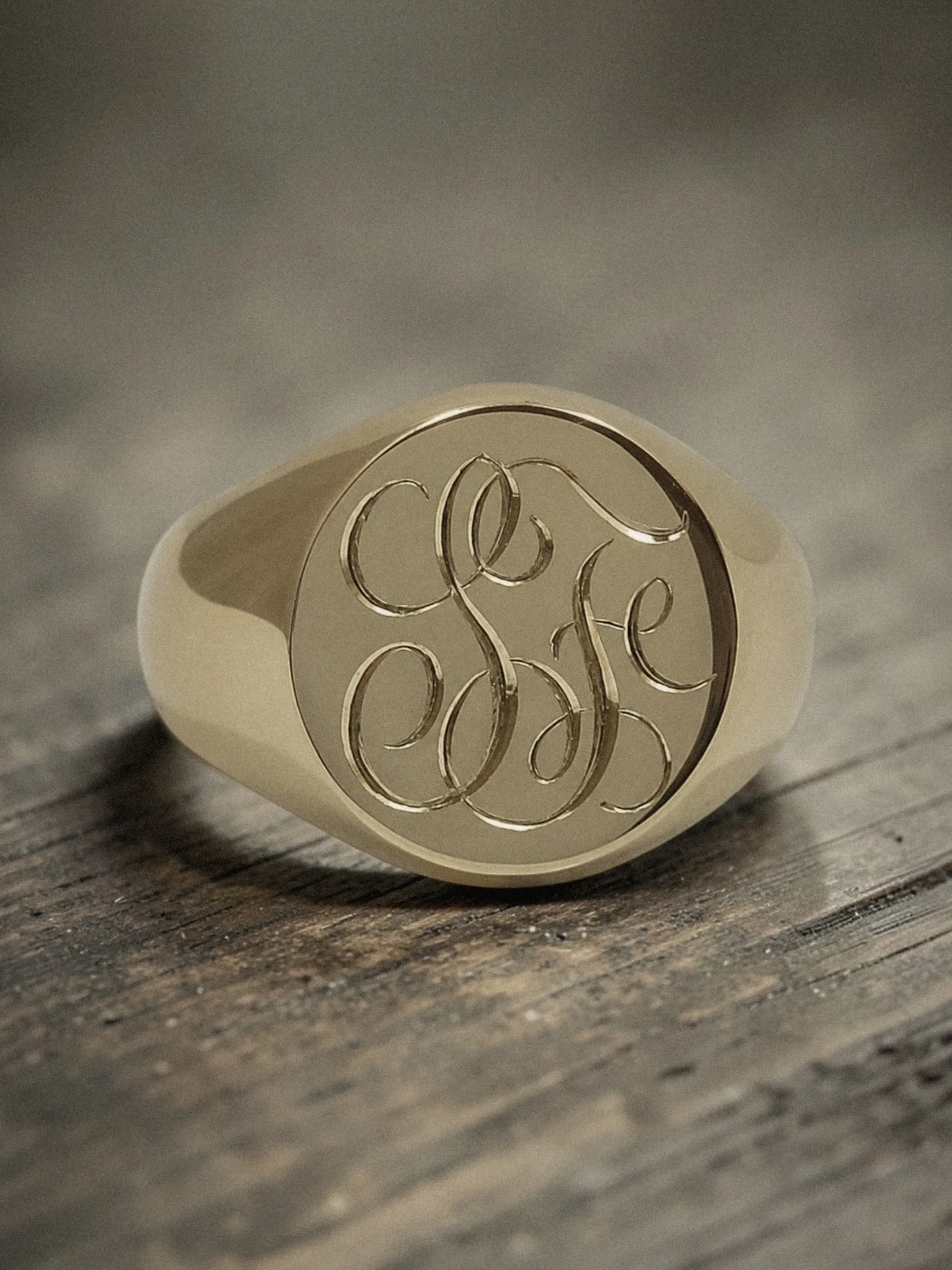 Close-up of an expertly hand engraved gold signet ring with a personalised bespoke custom monogram design.