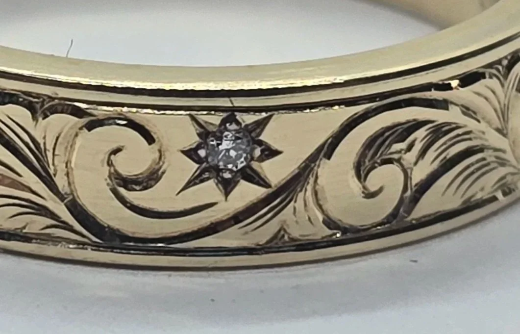 A hand engraved gold scroll band