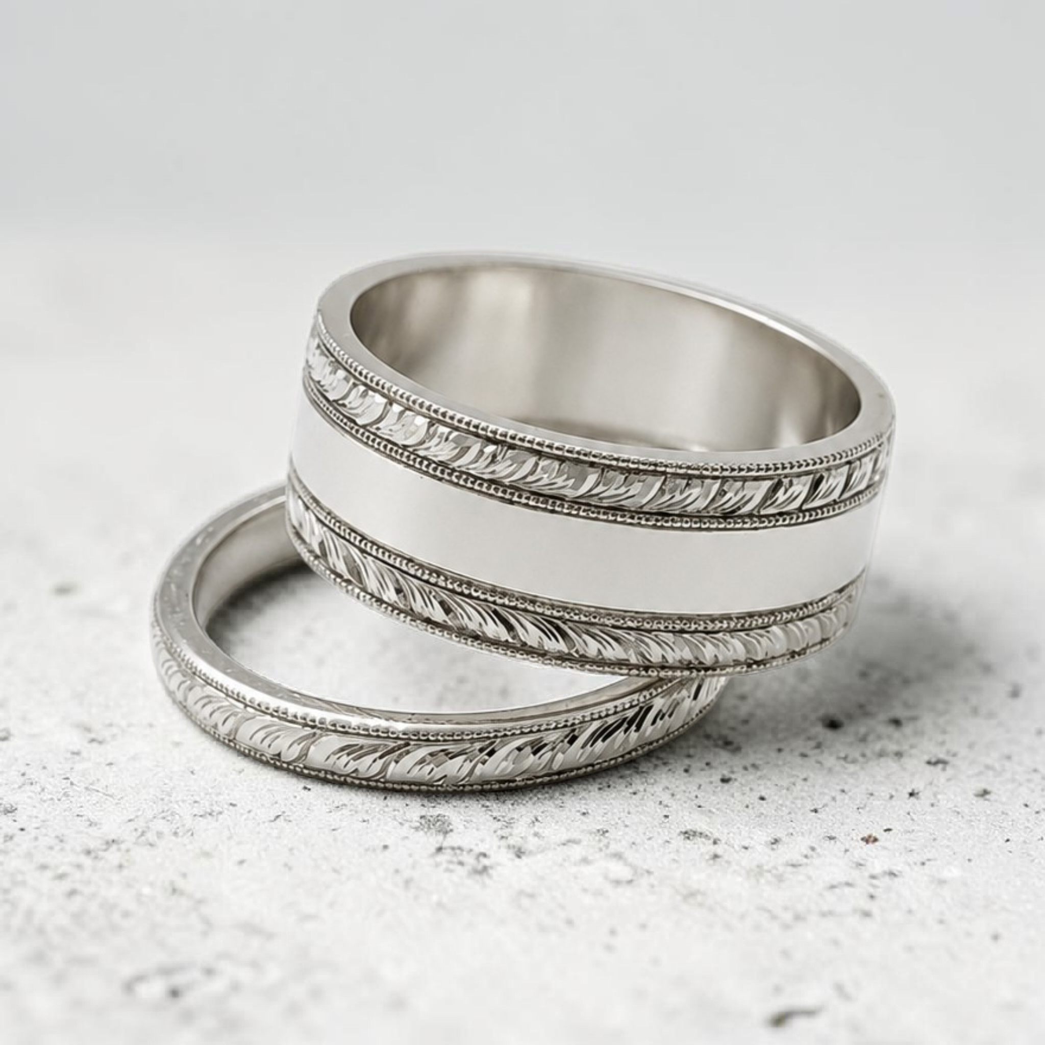 Close-up of a sterling silver wedding or engagement band featuring a unique bespoke botanical hand engraved pattern.