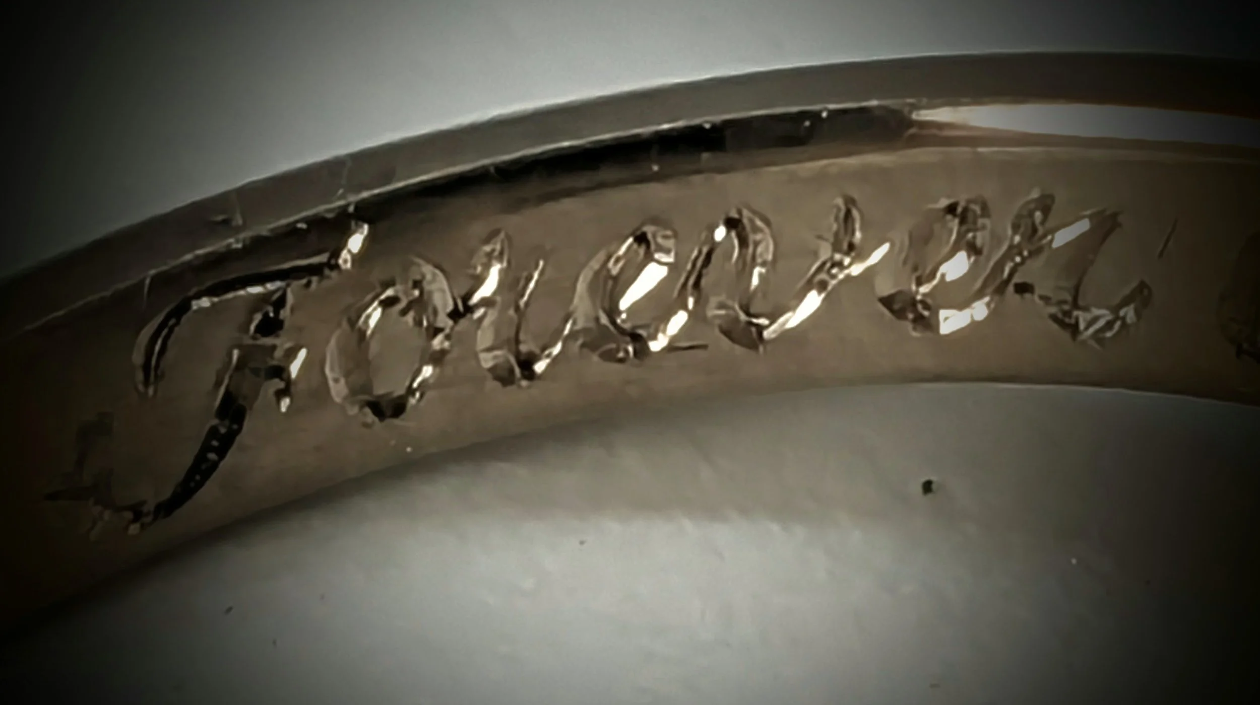 Close-up of inside ring hand engraving, a romantic inscription inside a gold wedding band