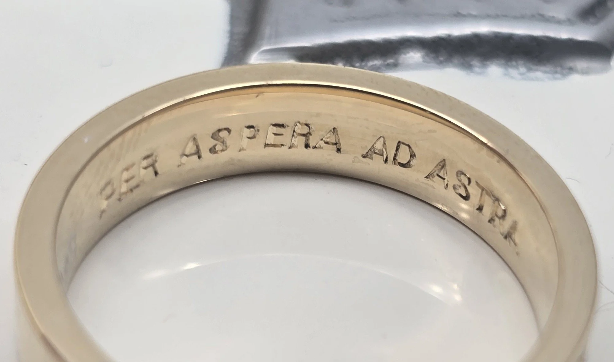 Close-up of a gold ring with an internal hand engraved romantic inscription.