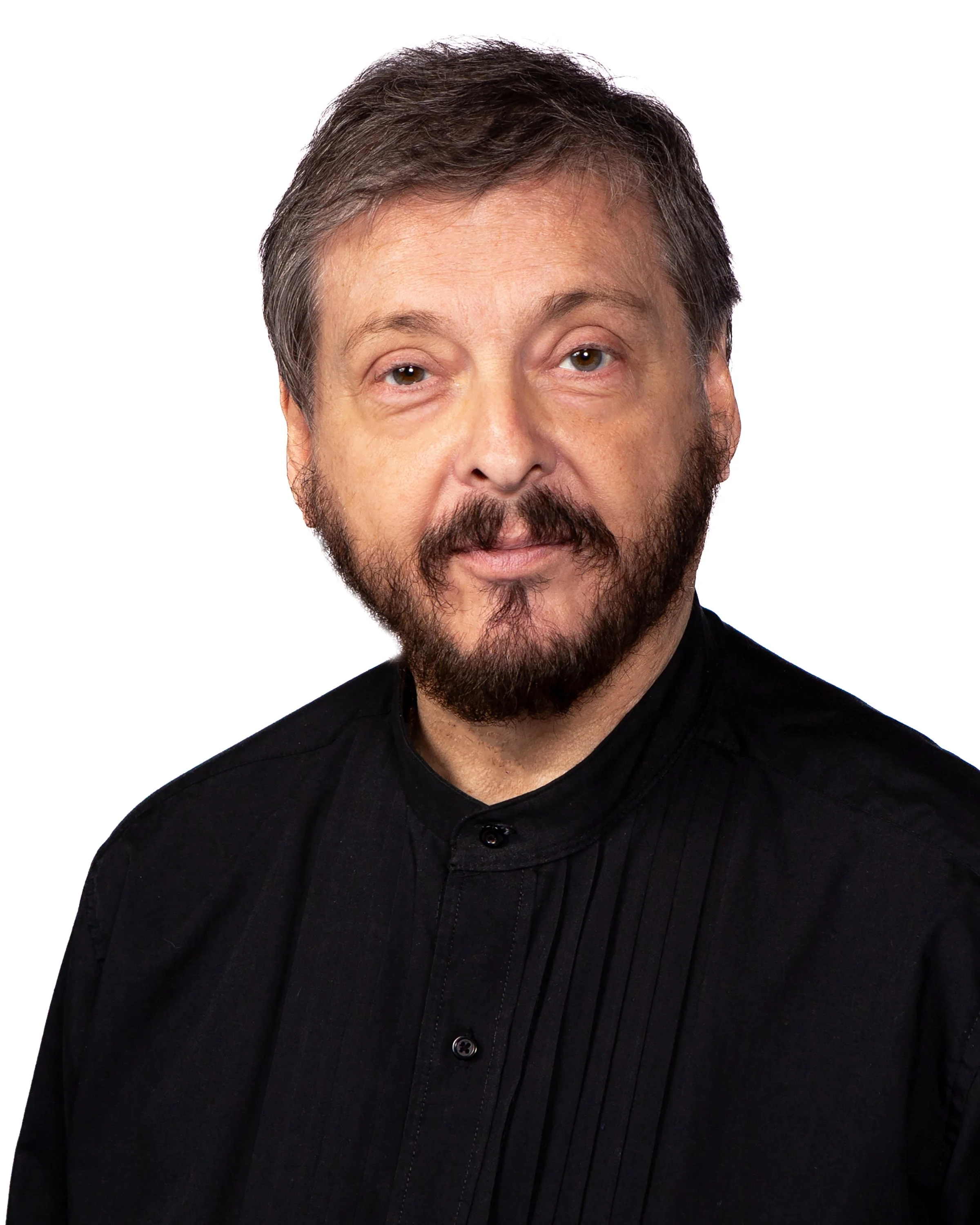 Close-up photo of a man with dark hair, brown eyes, and a beard, wearing a black shirt, against a white background.