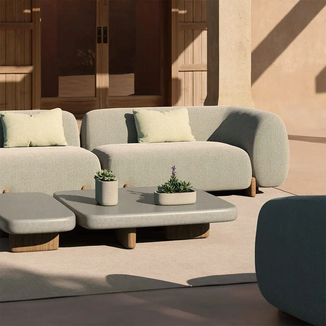 Sunlit modern patio with cream sofas, gray coffee table, potted succulents, wooden doors, and bold architectural shadows creating a calm mood.