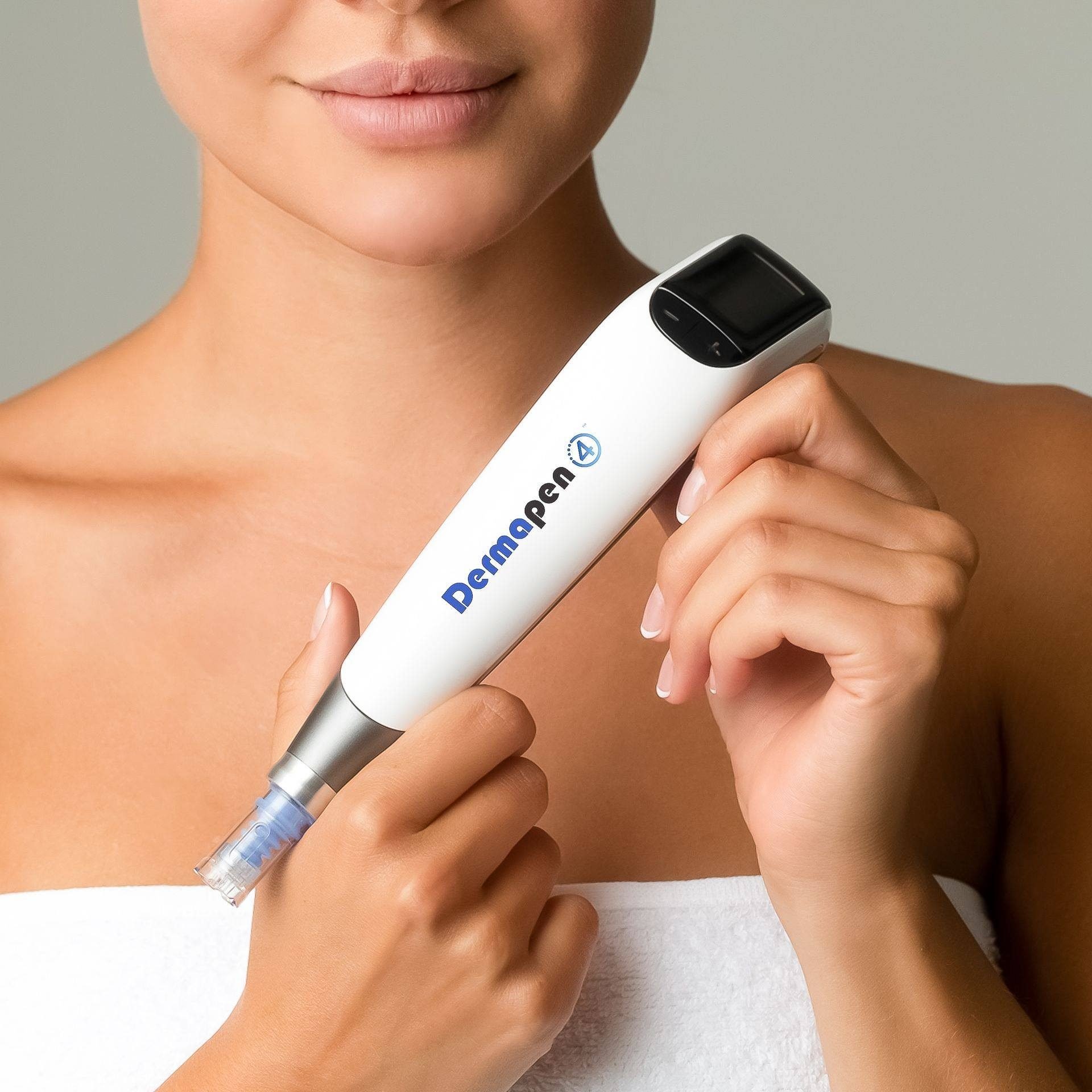 Close-up of a woman performing a skin analysis using a handheld skin scanner on her face, with a light grey background.