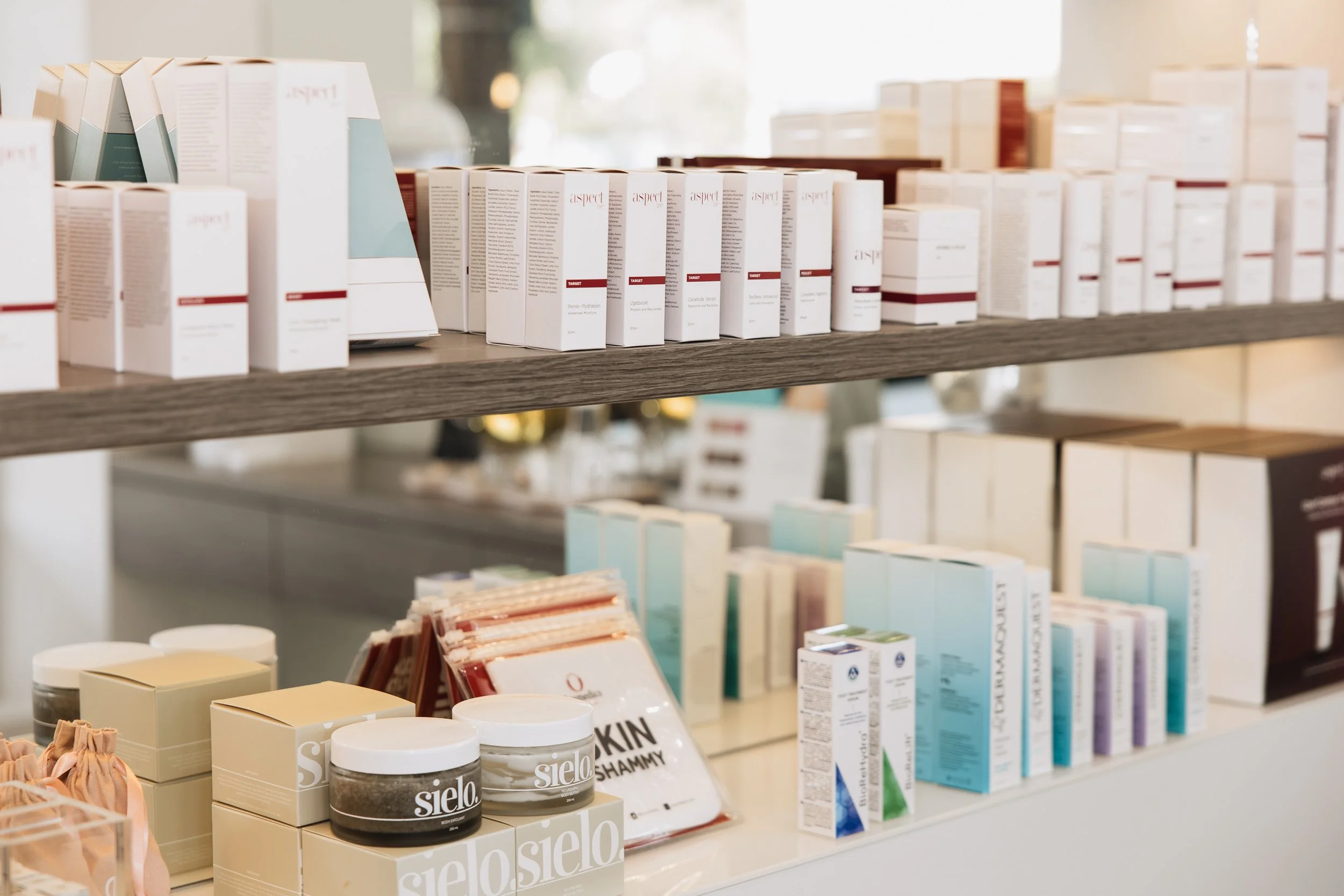 Display of various skincare and beauty products on shelves at a store, including Sielo skincare jars, pathway, boxes, and bottles.