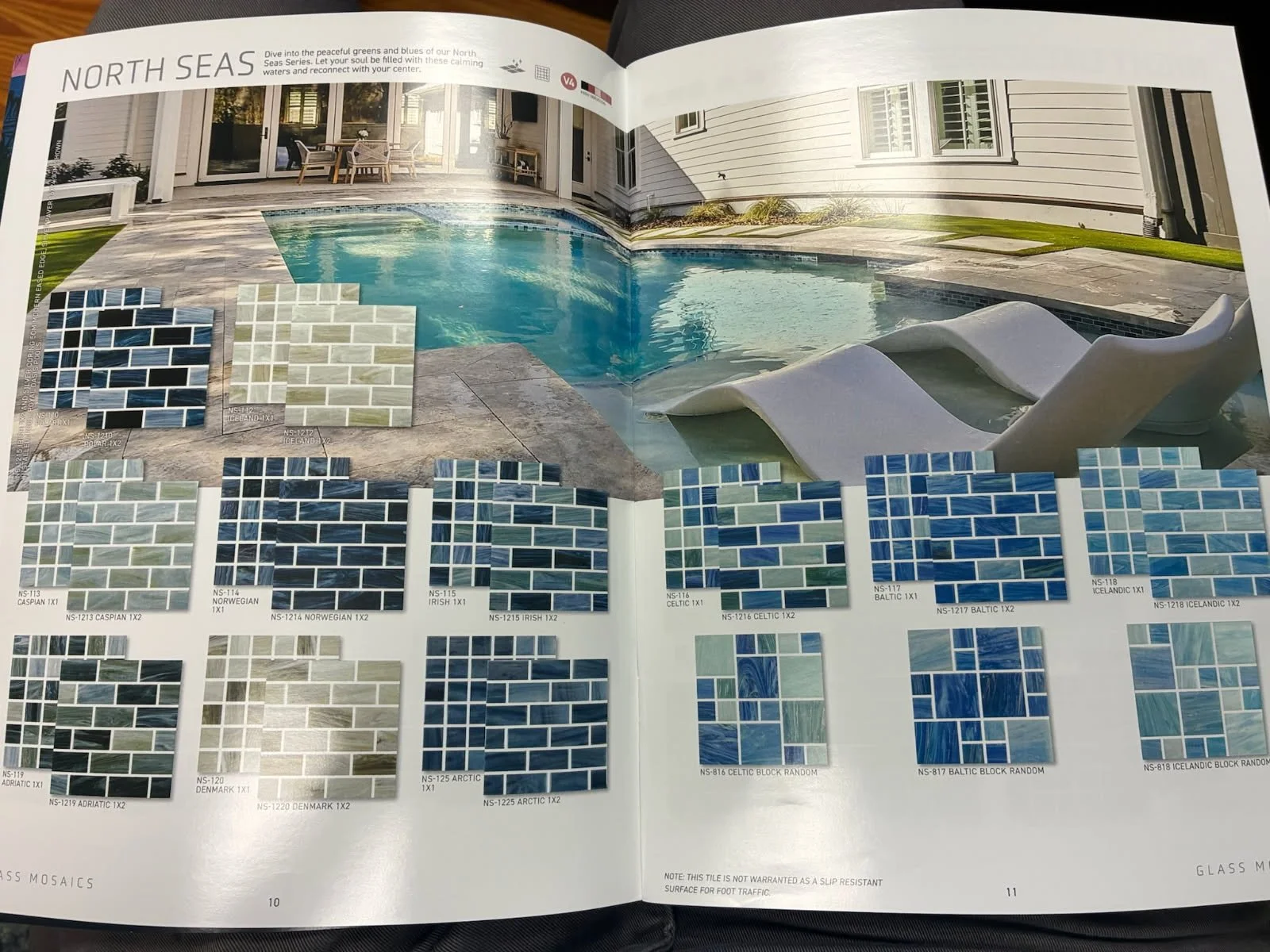 Open catalog showing a backyard pool with tile samples below, including various shades of blue, green, black, and white rectangular tiles organized in rows and columns.