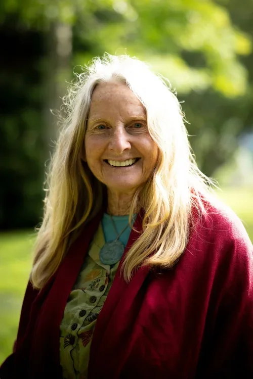 Robina McCurdy smiling into the camera, with a red jumper on.