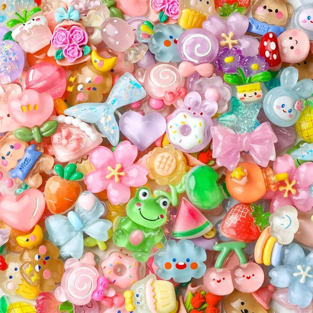 A colorful collection of small, cute, plastic charms and toys including hearts, flowers, animals, and food items like strawberries and watermelons.