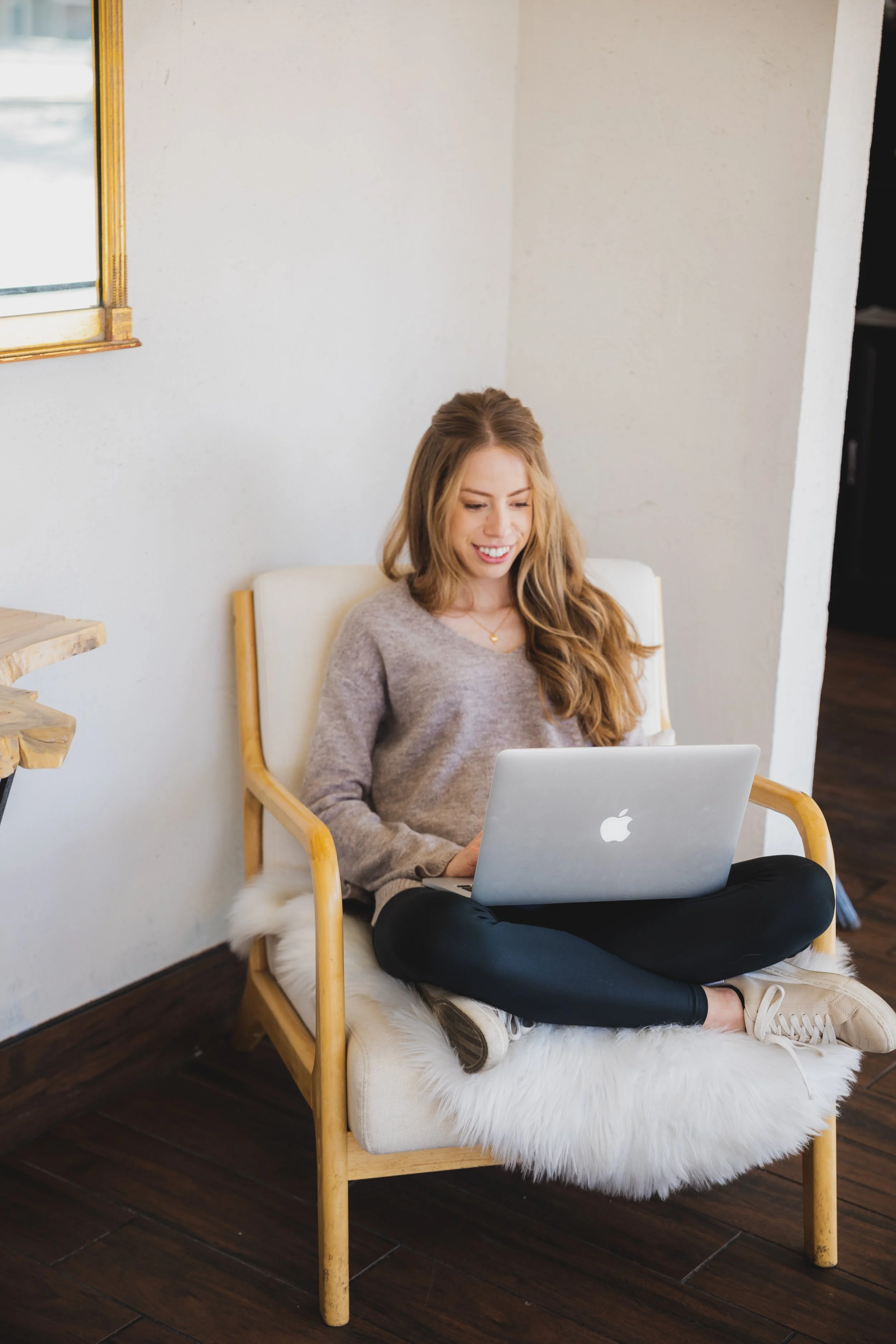  Woman working from couch with laptop and notebook