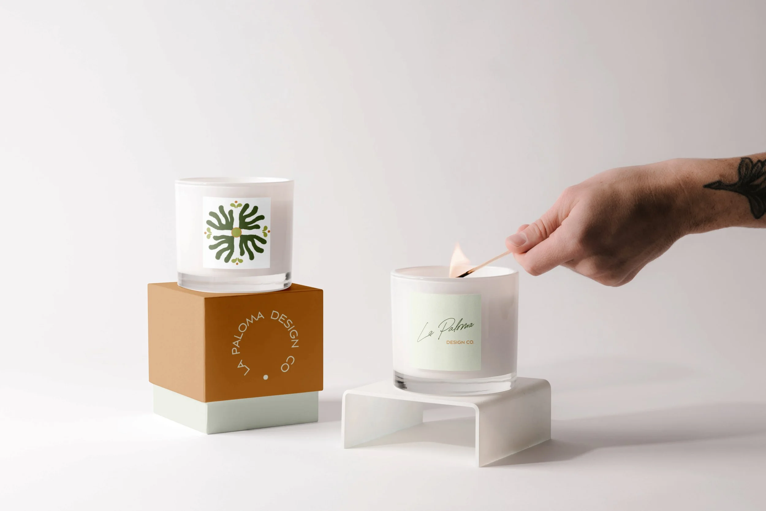 Semi-custom brand illustration and logo displayed on candle packaging.