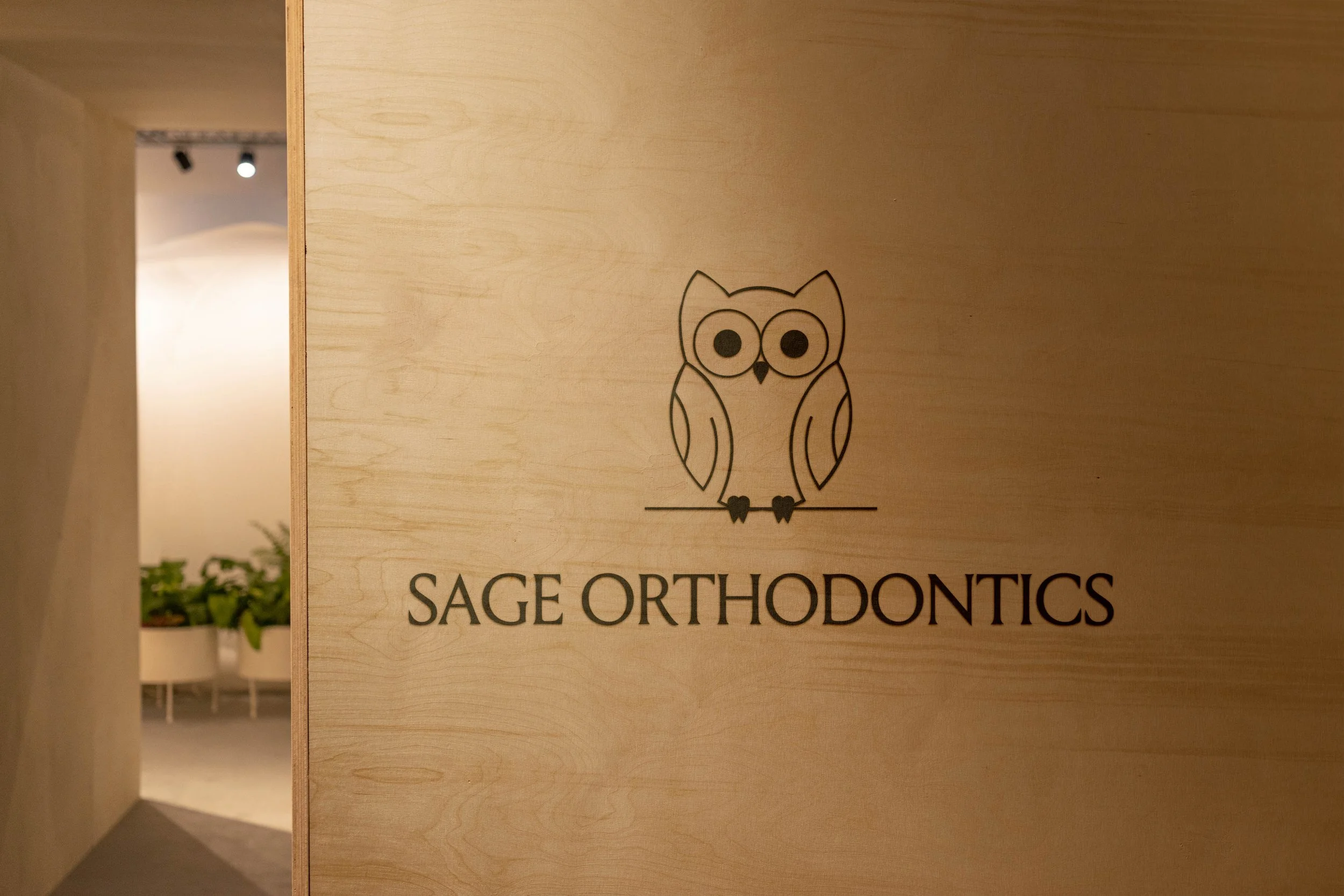 Sage Orthodontics logo design displayed on a wall.