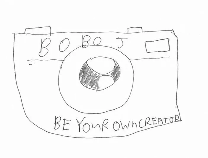 Hand-drawn camera with the word 'BOOBS' and the phrase 'BE YOUR OWN CREATOR' written on it.
