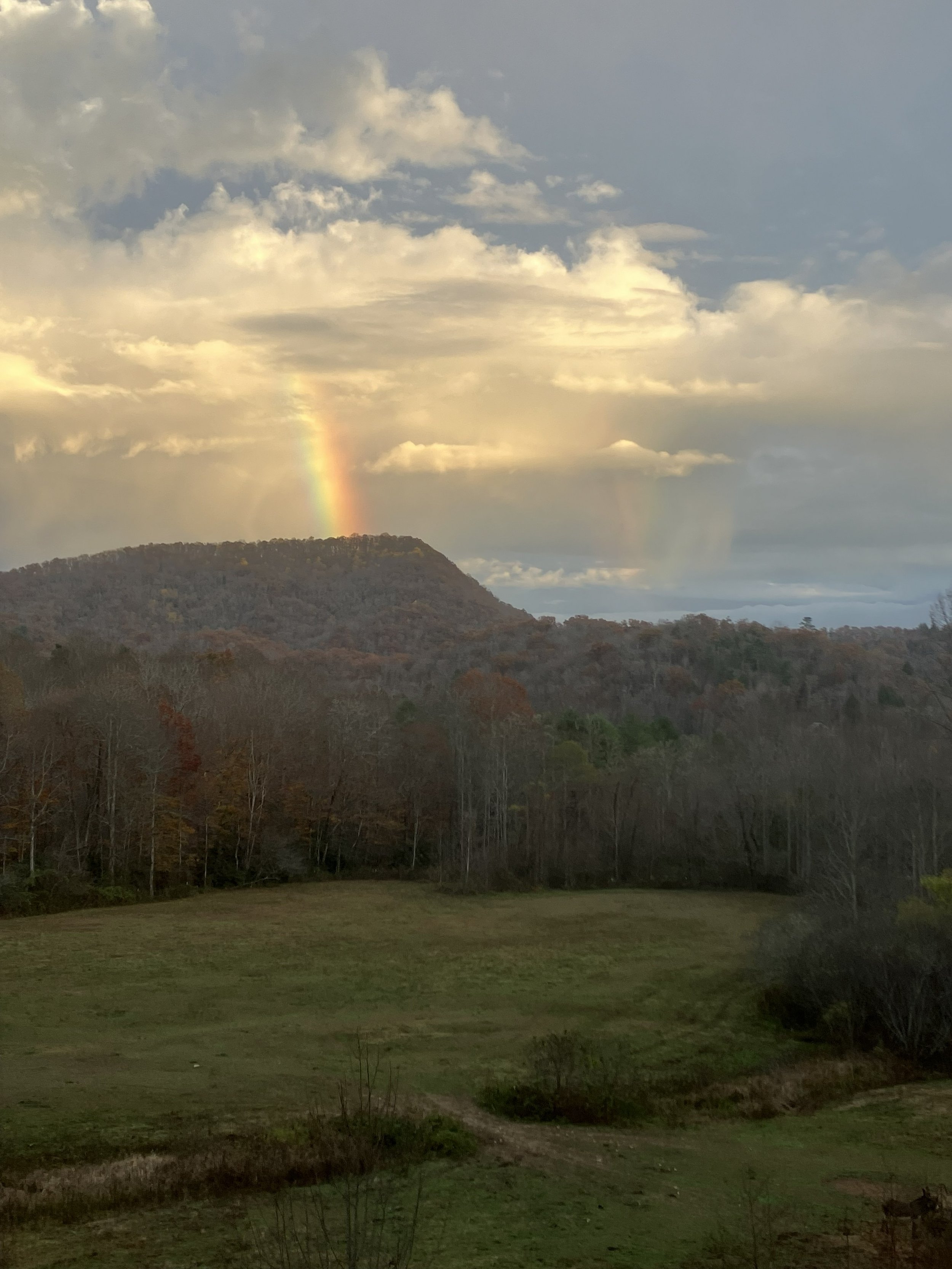 A mountain rainbow shining through the clouds over the valleys of Western North Carolina.