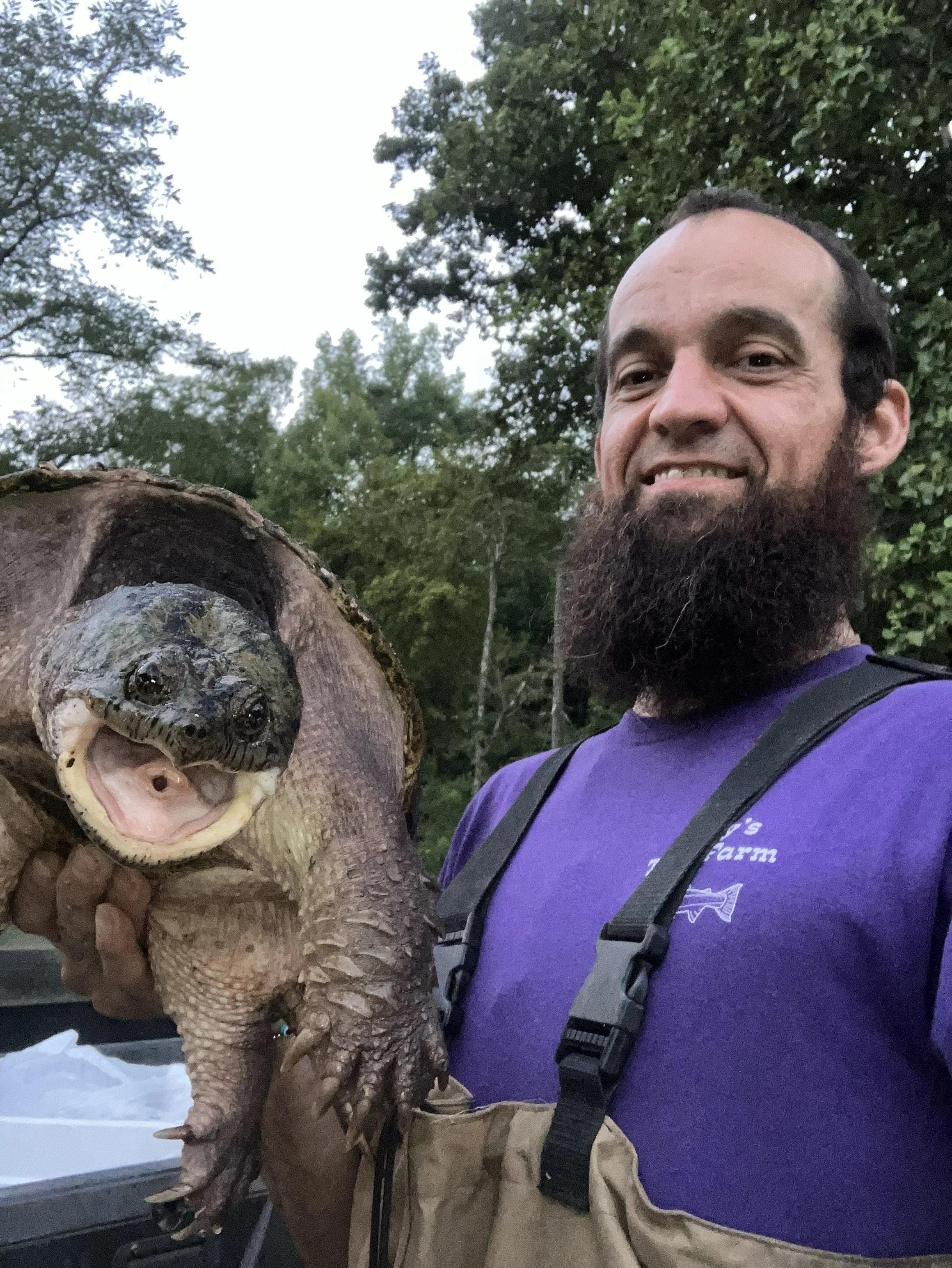 Holding a native turtle after safely removing it from a trout pond drain in Western North Carolina.