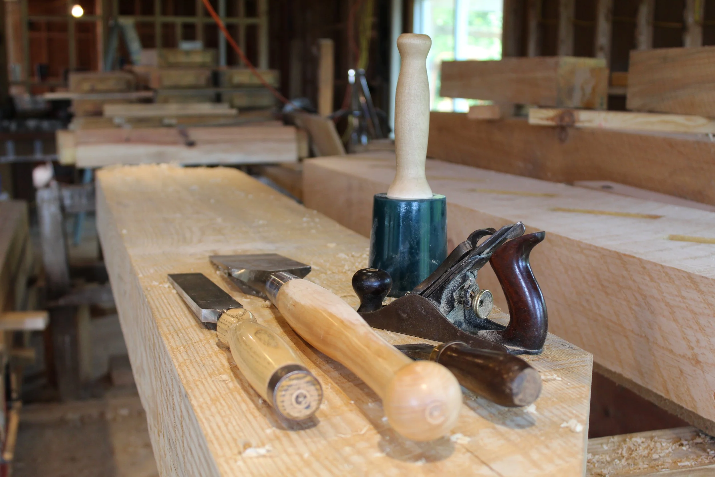 Traditional woodworking tools resting on a hand-crafted staircase stringer, ready for the next stage of the build.