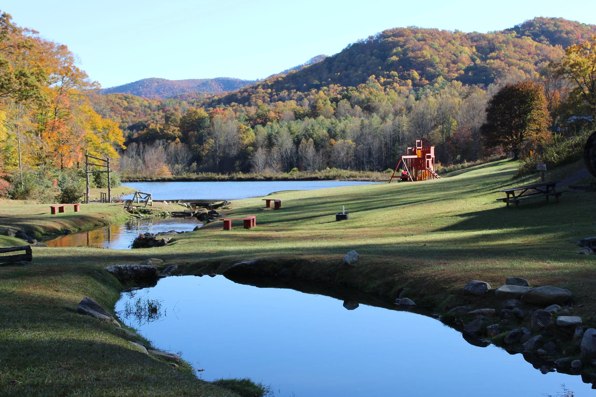 Mountain trout ponds surrounded by autumn foliage in the Appalachian Mountains at Andy's Trout Farm in Otto, North Carolina.