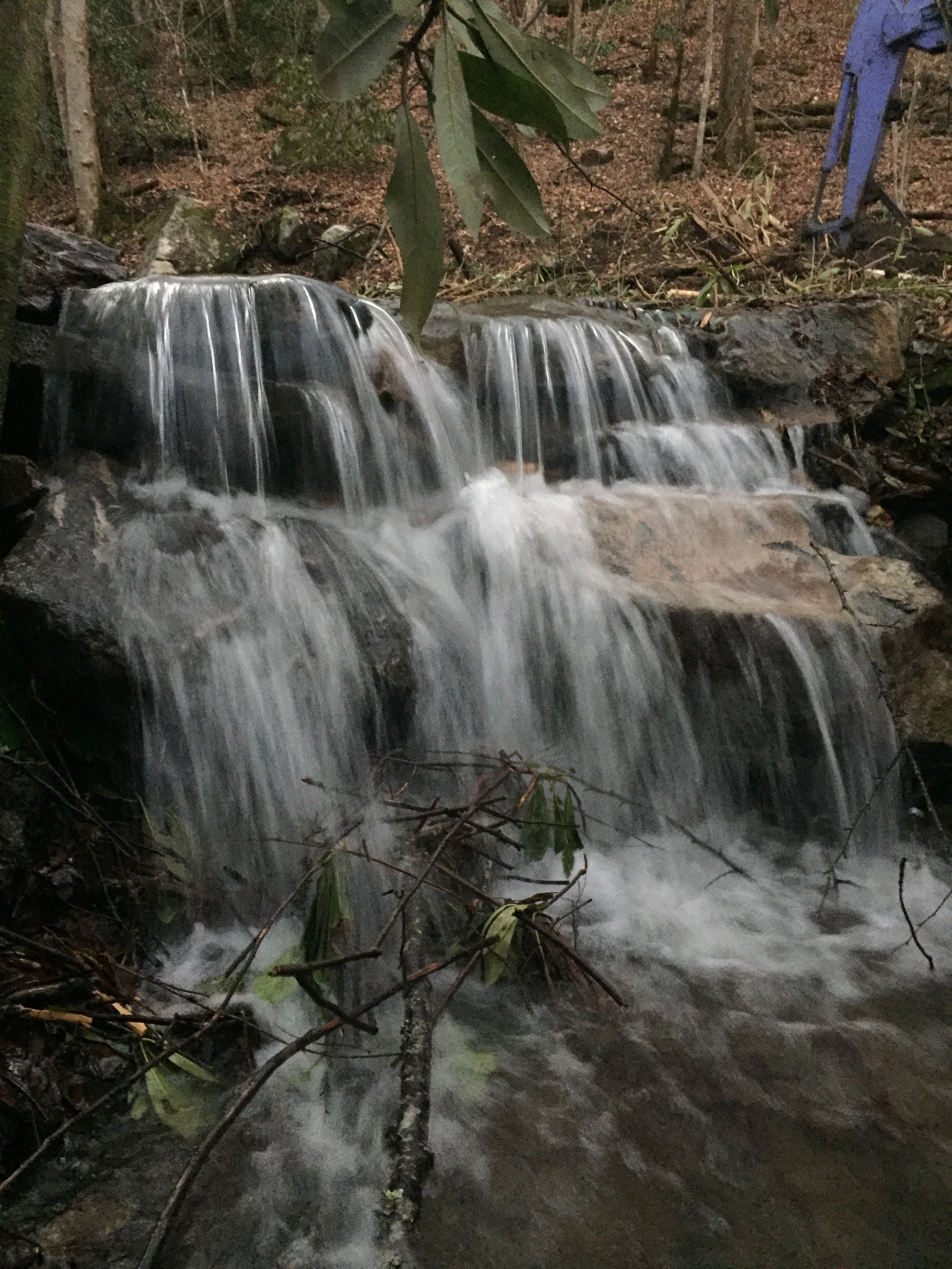 A cascading mountain waterfall flowing over natural rock formations in the forests of Western North Carolina.