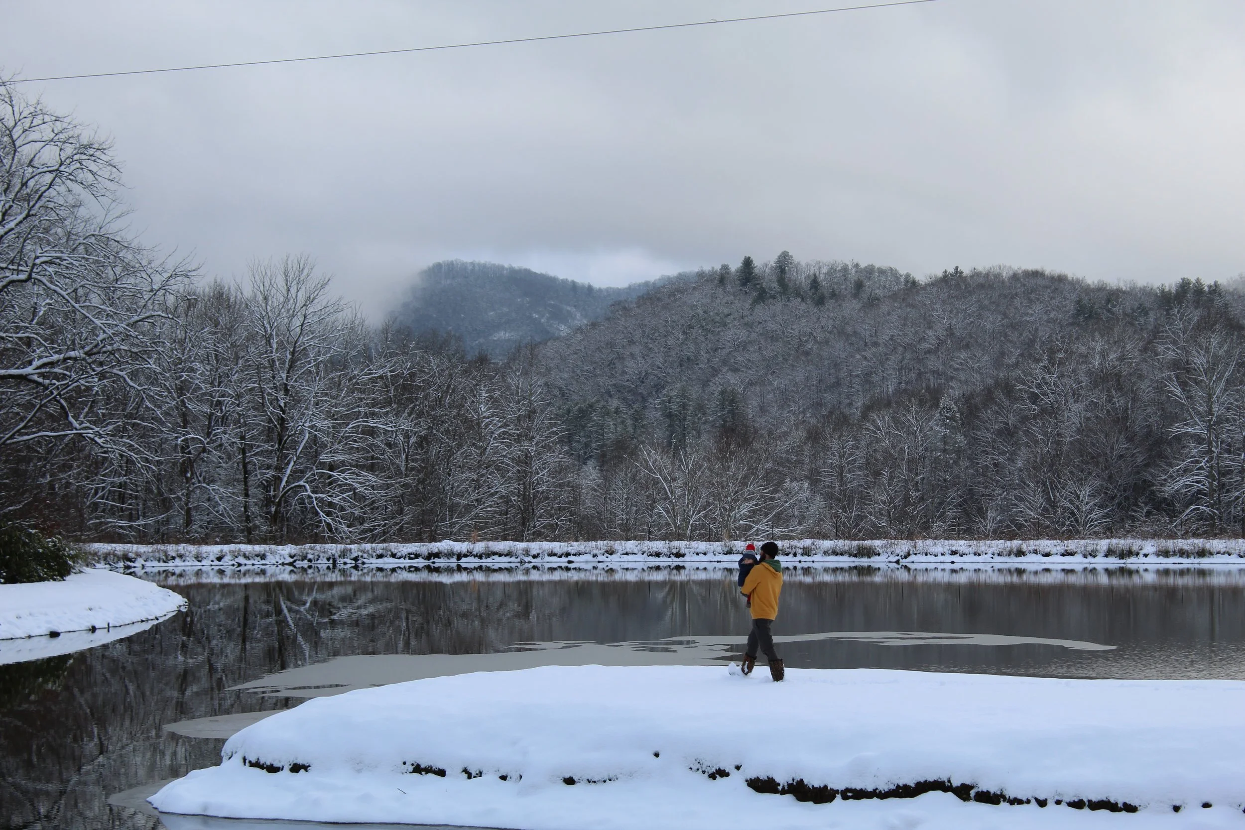 Winter settles over the trout ponds as a father and son walk together through the mountain landscape.