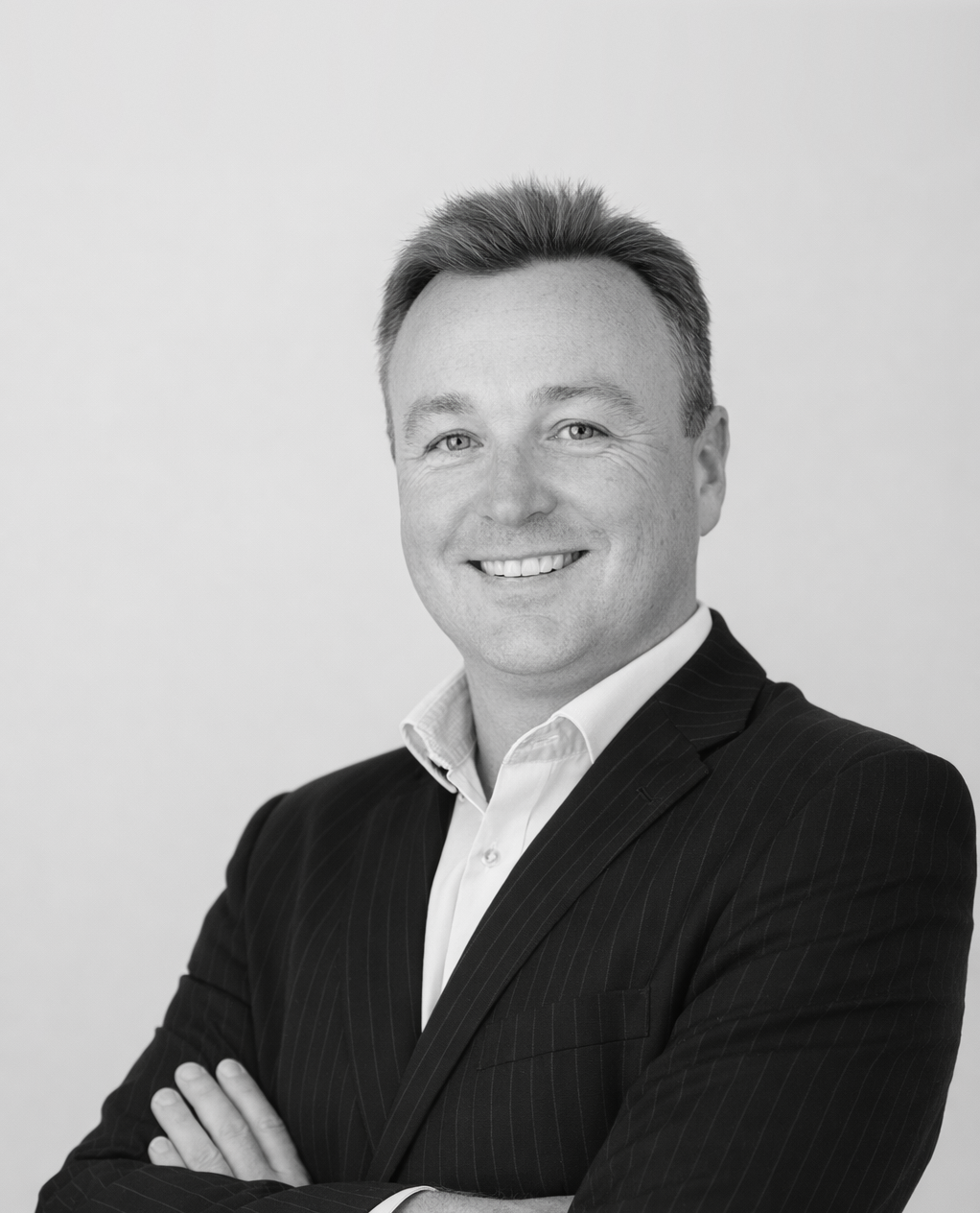 Lachlan St Clair, Partner at Oreana Advice Partners in a suit with arms crossed, facing the camera.