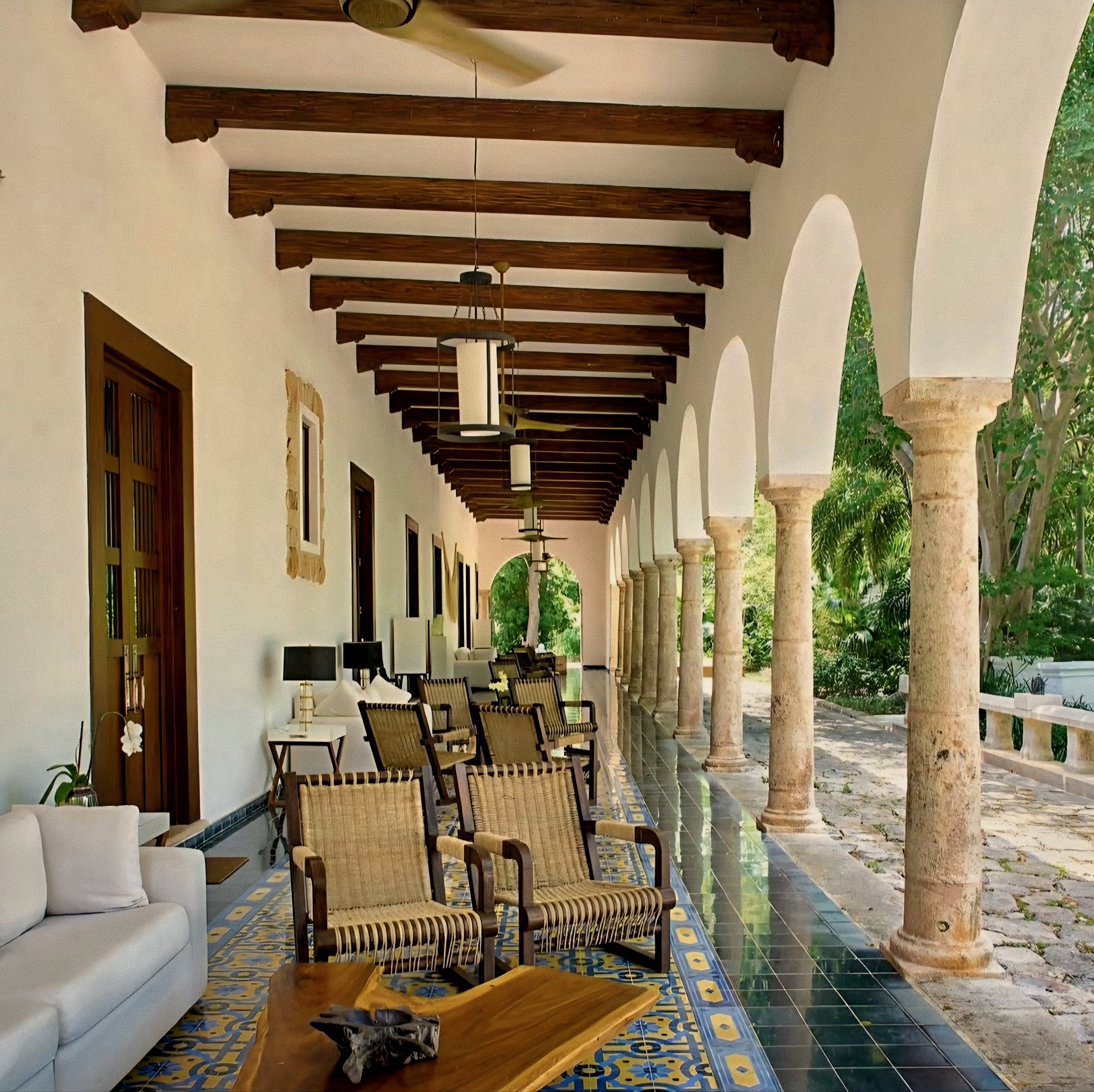 Colonial arch loggia and woven armchairs at Hacienda Chablé Yucatán, Chocholá, Mexico.