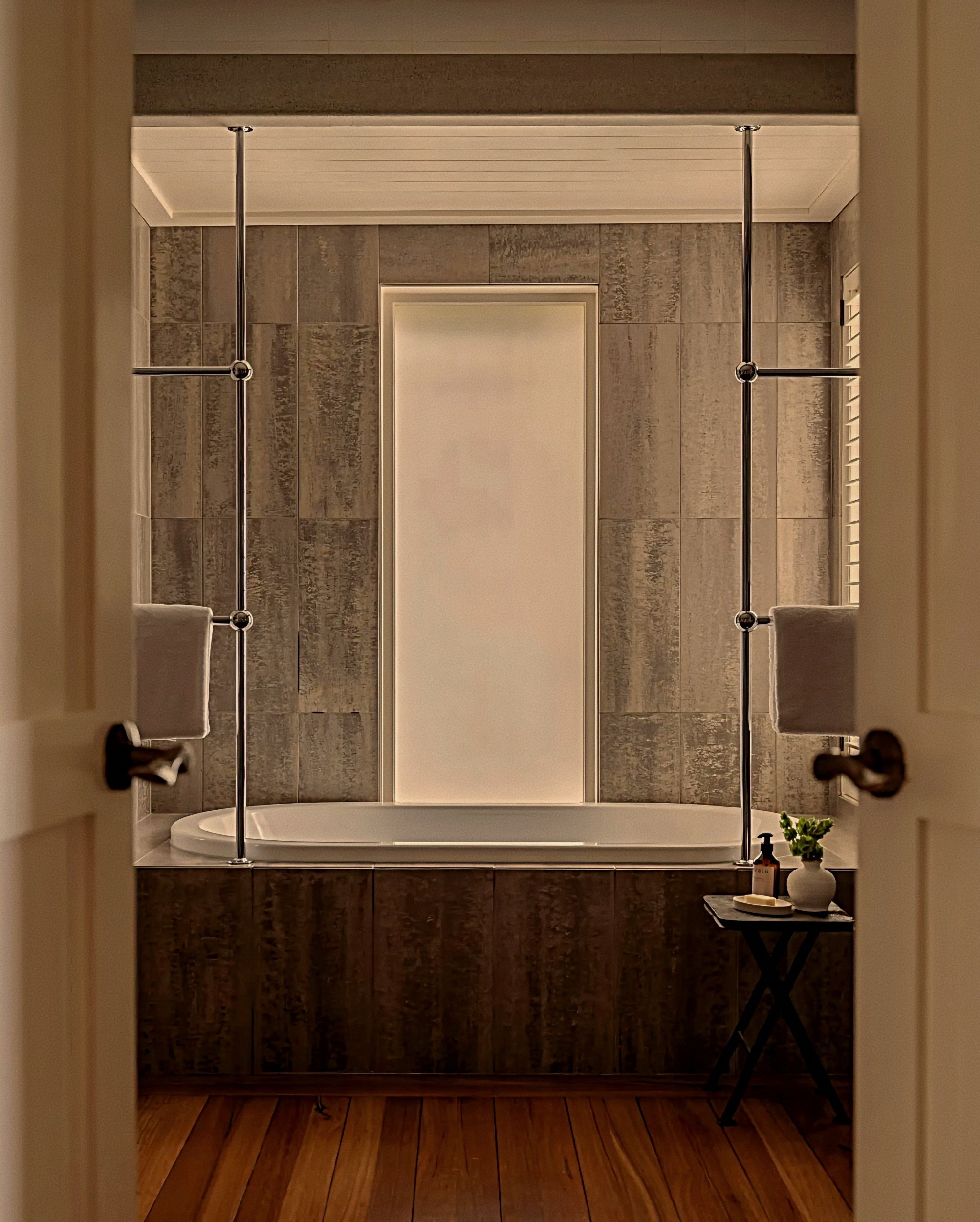 Deep soaking spa bath framed in textured stone at Rosewood Kauri Cliffs luxury resort in New Zealand.