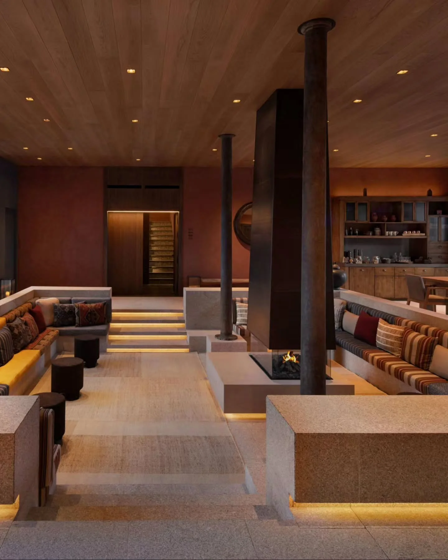 Terracotta-rendered plaster and wood ceiling joinery enclose a central floating glass fireplace, flanked by stepped stone plinths and slender timber pillars. 

​Interior Design by Clodagh Design International.

​The Lounge at @sixsensesdourovalley

​