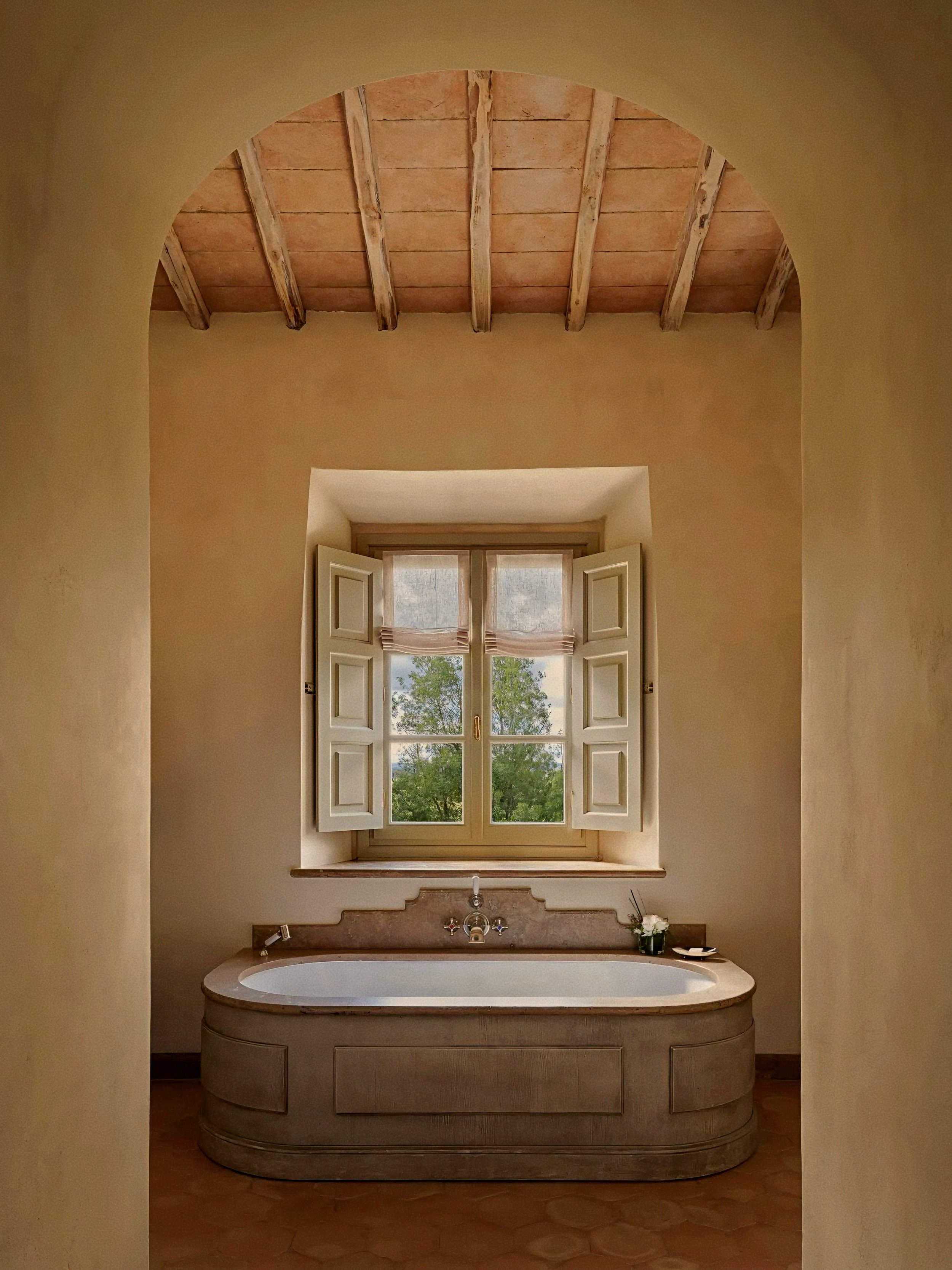 Soaking tub and arched window at Castiglion del Bosco, A Rosewood Hotel, Val d'Orcia, Tuscany, Italy.