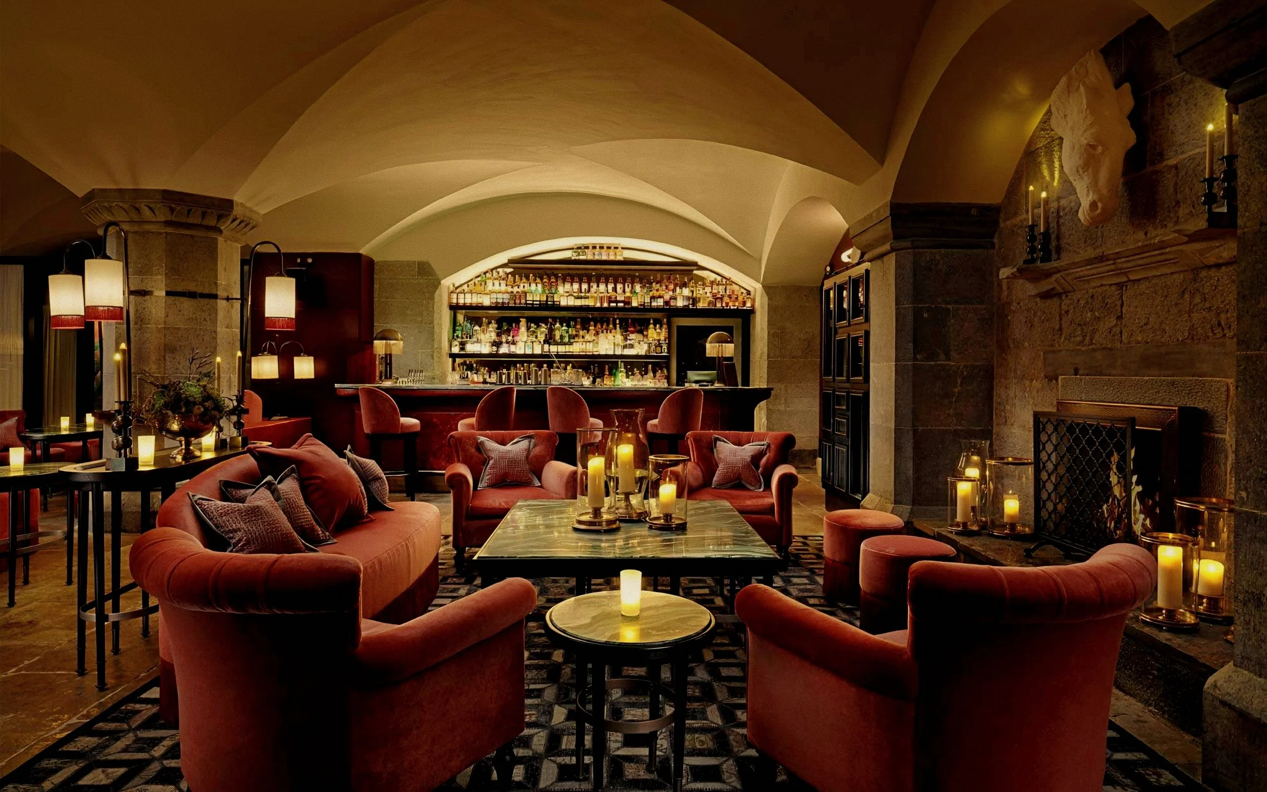 Vaulted stone cellar and velvet seating in bar room at Adare Manor luxury hotel in Ireland.