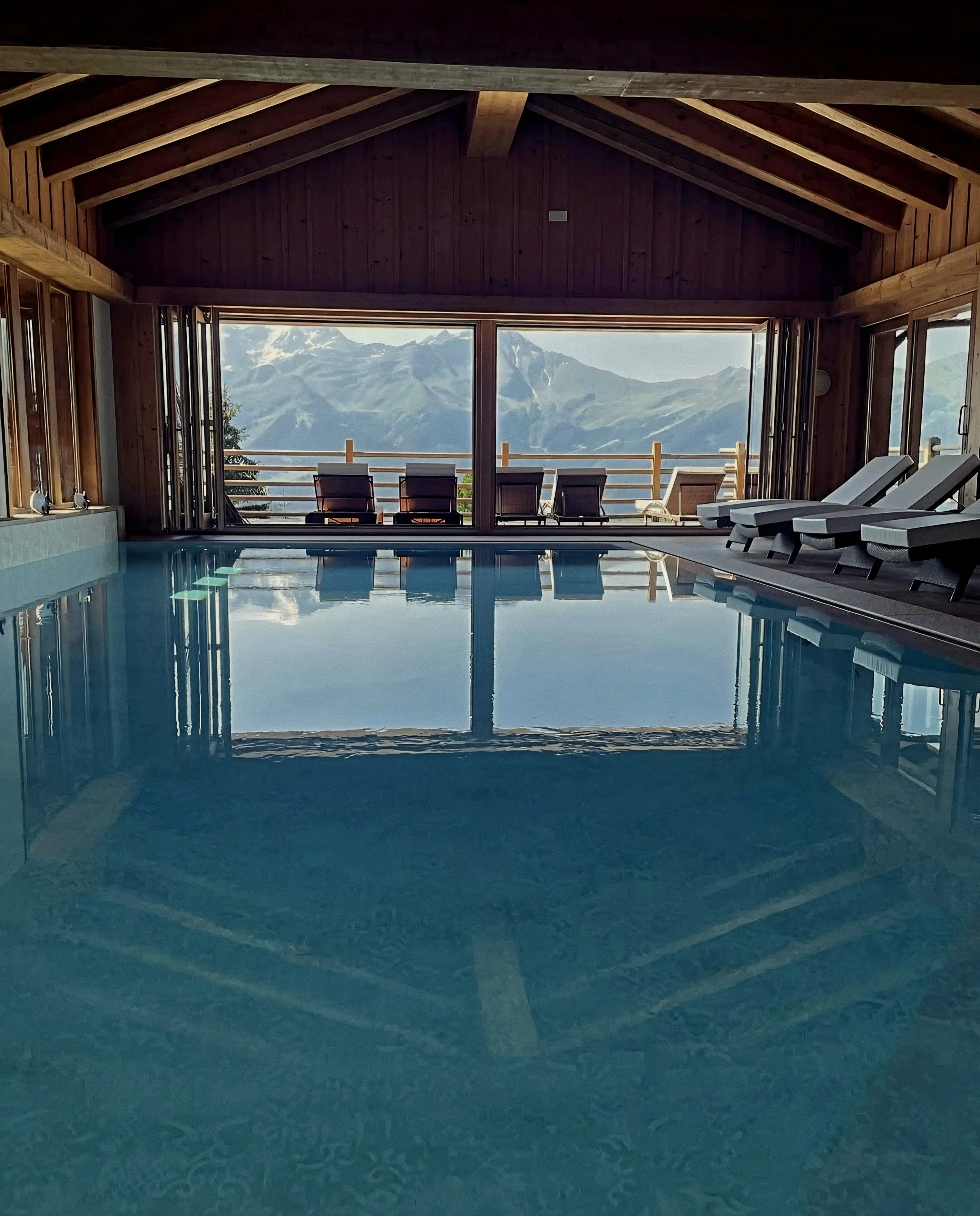 Indoor pool and Alpine mountain vistas at Le Chalet d’Adrien Luxury Swiss Alps in Verbier, Valais, Switzerland.