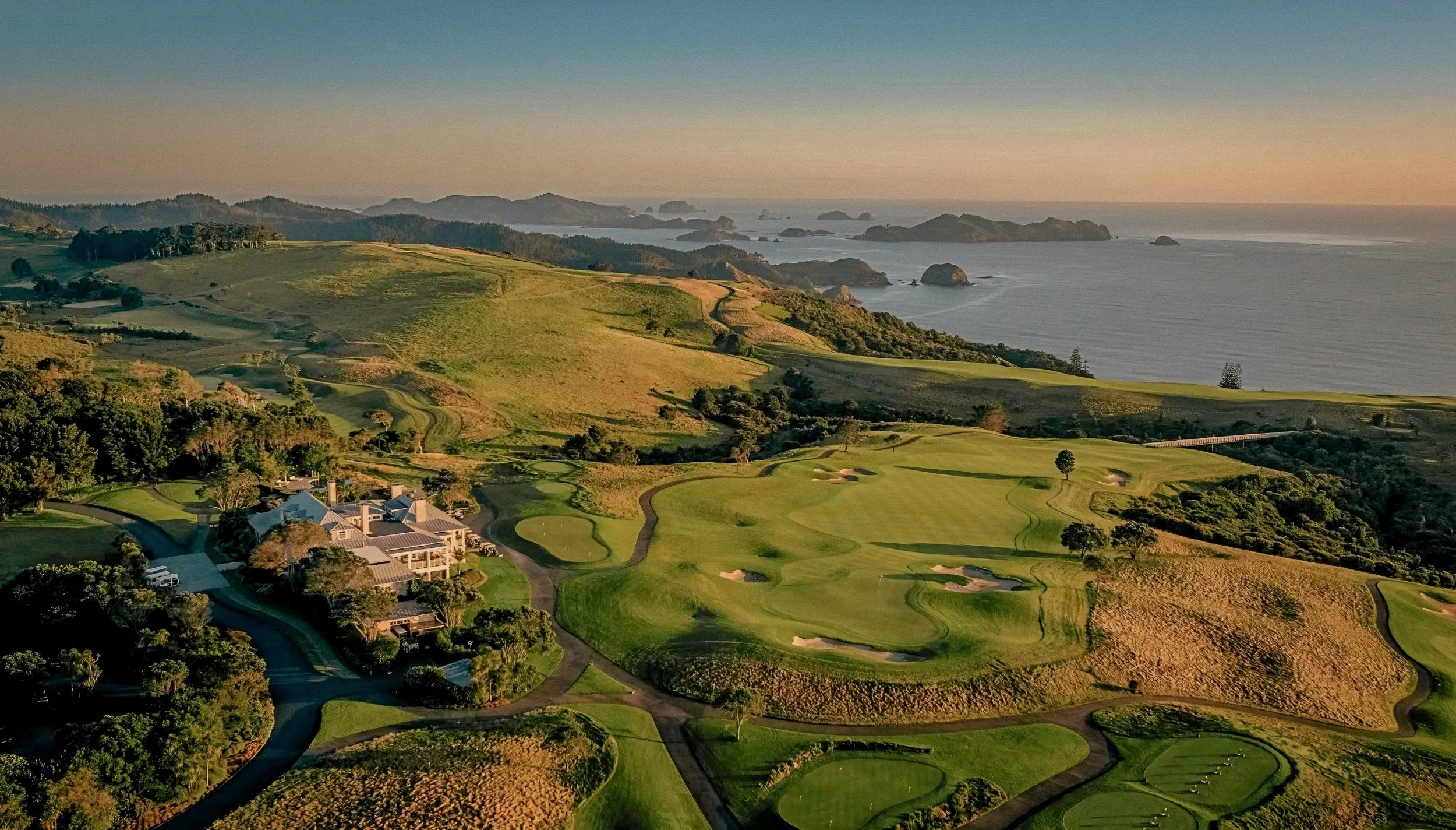 Championship golf course fairways overlooking Matauri Bay ocean bluffs at Rosewood Kauri Cliffs, New Zealand.