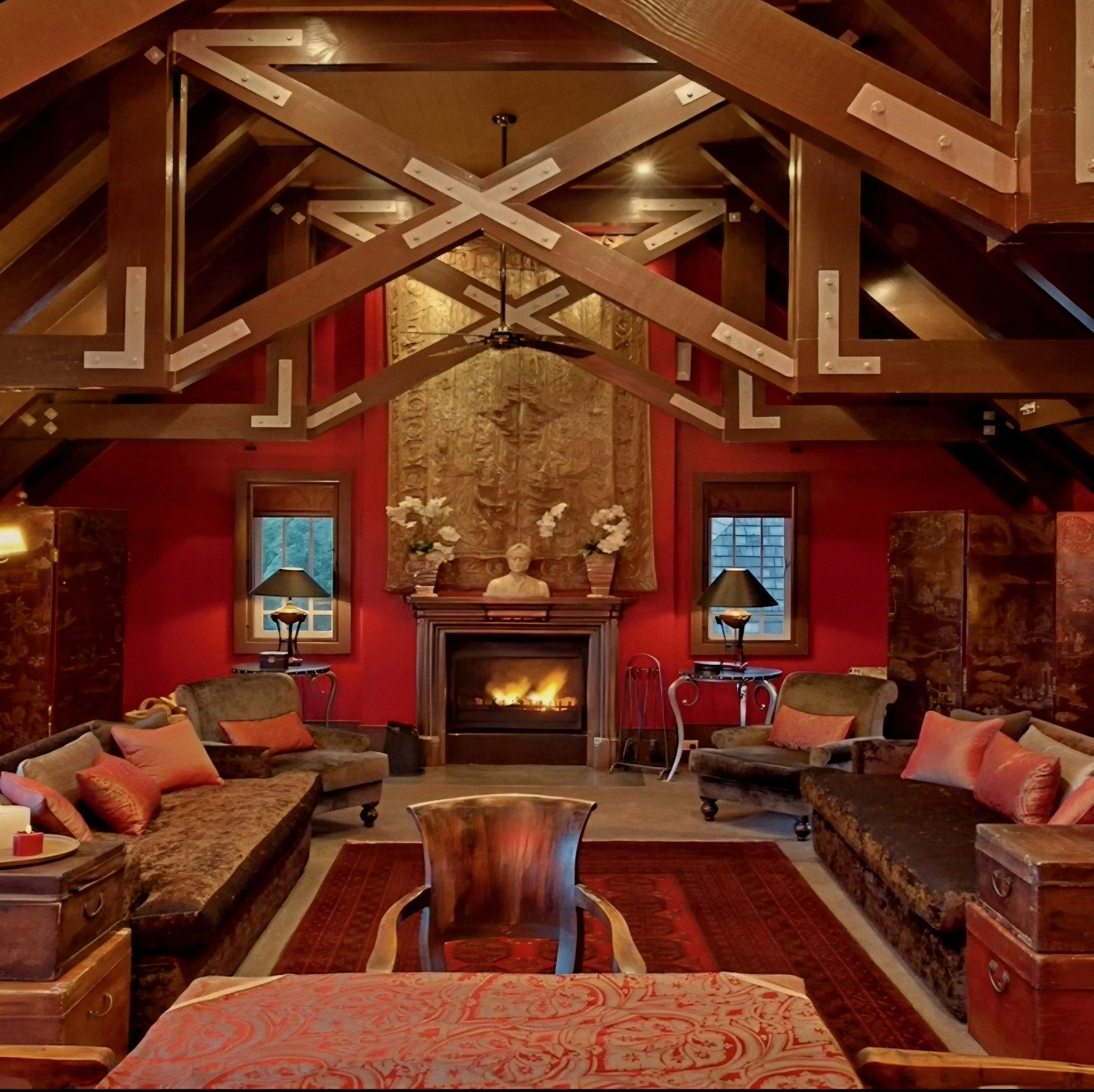 Crimson fireside lounge with exposed wooden ceiling trusses by Virginia Fisher at Wharekauhau Lodge, New Zealand.