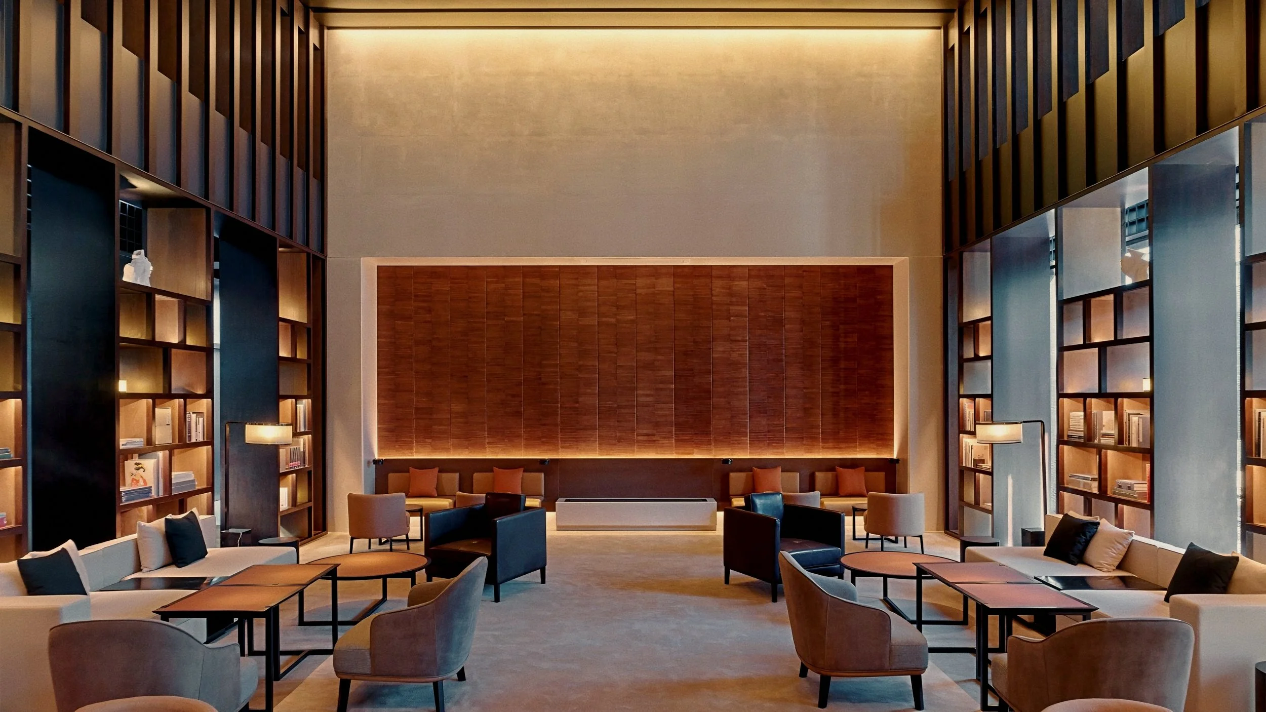 Double height library bookcases and velvet armchairs At The PuXuan Hotel and Spa in Beijing, China.