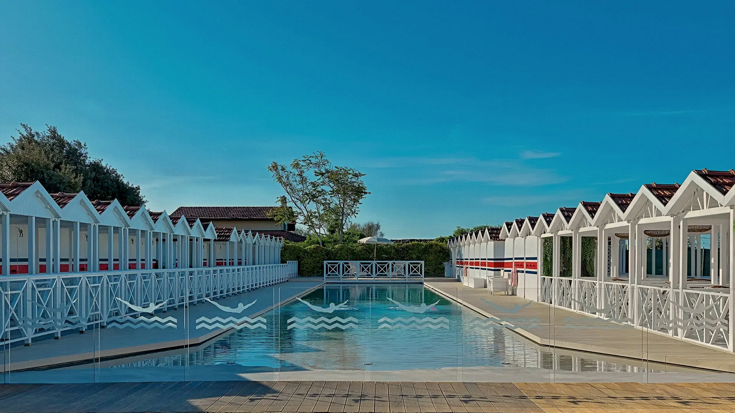 Canvas beach cabanas framing the private pool deck at Augustus Beach Club in Forte dei Marmi, Tuscan Riviera.