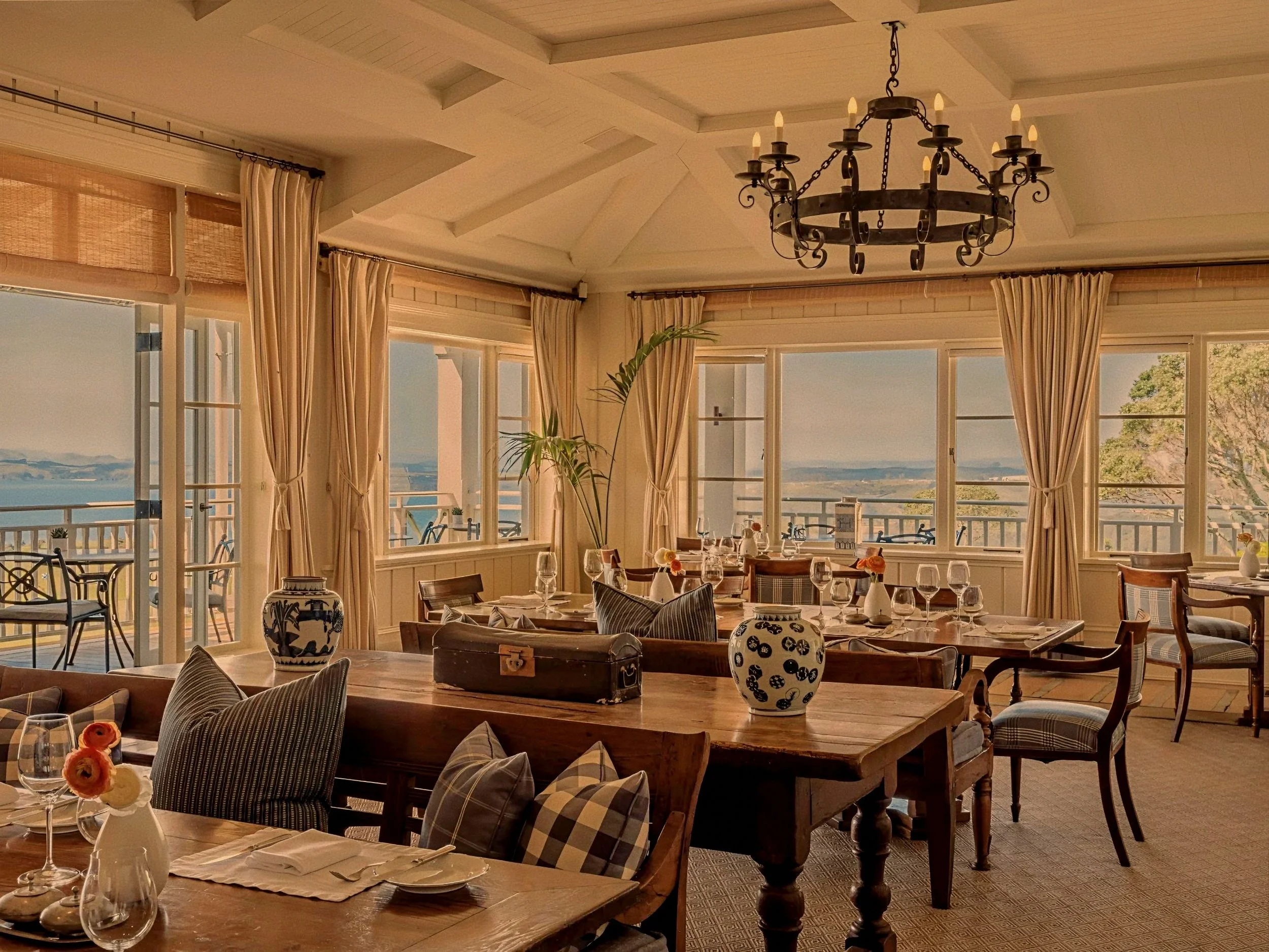 Ocean-view luxury lodge dining room by Virginia Fisher at Rosewood Kauri Cliffs in Northland, New Zealand.