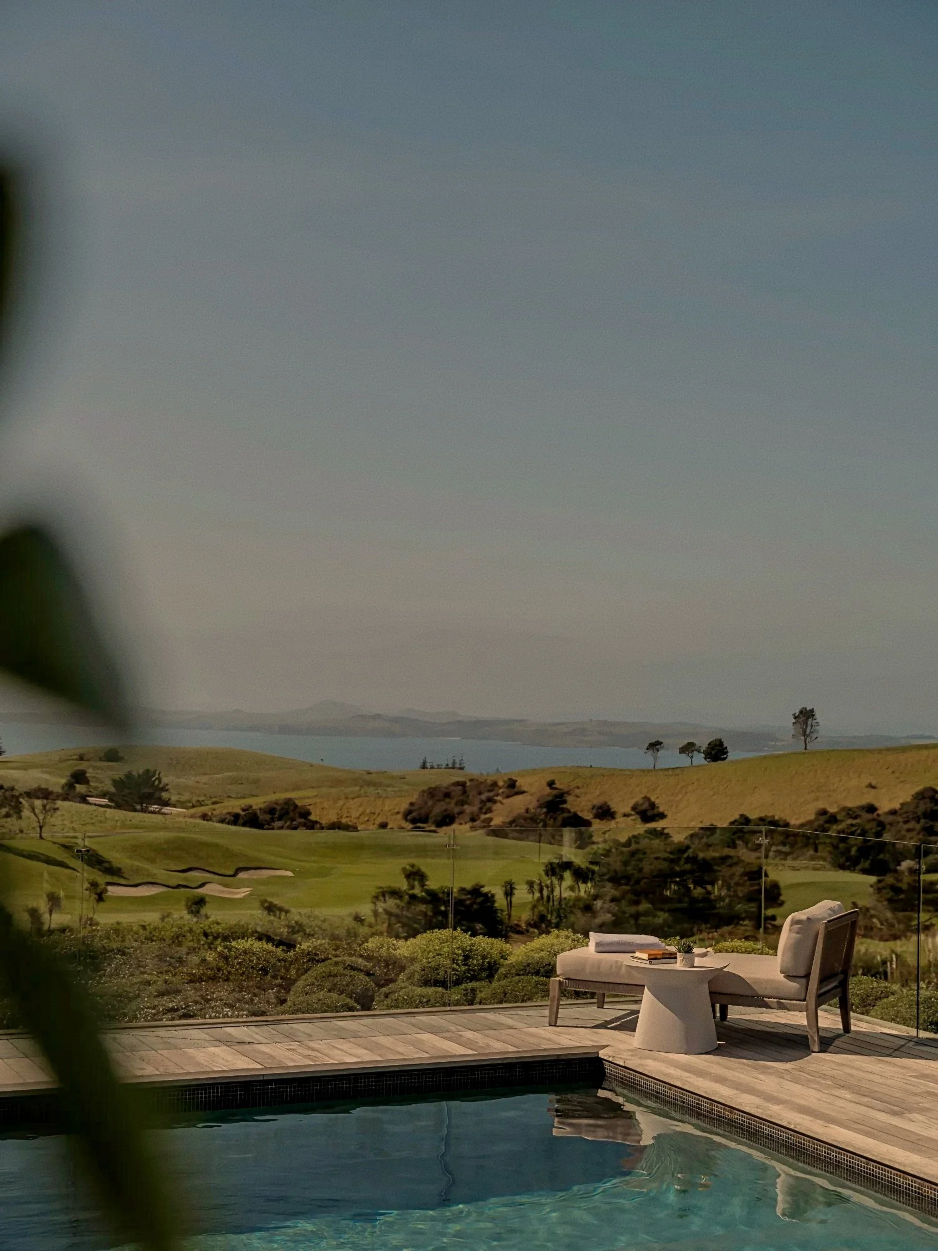 Villa infinity pool terrace overlooking Cavalli Islands at Rosewood Kauri Cliffs luxury estate, New Zealand.
