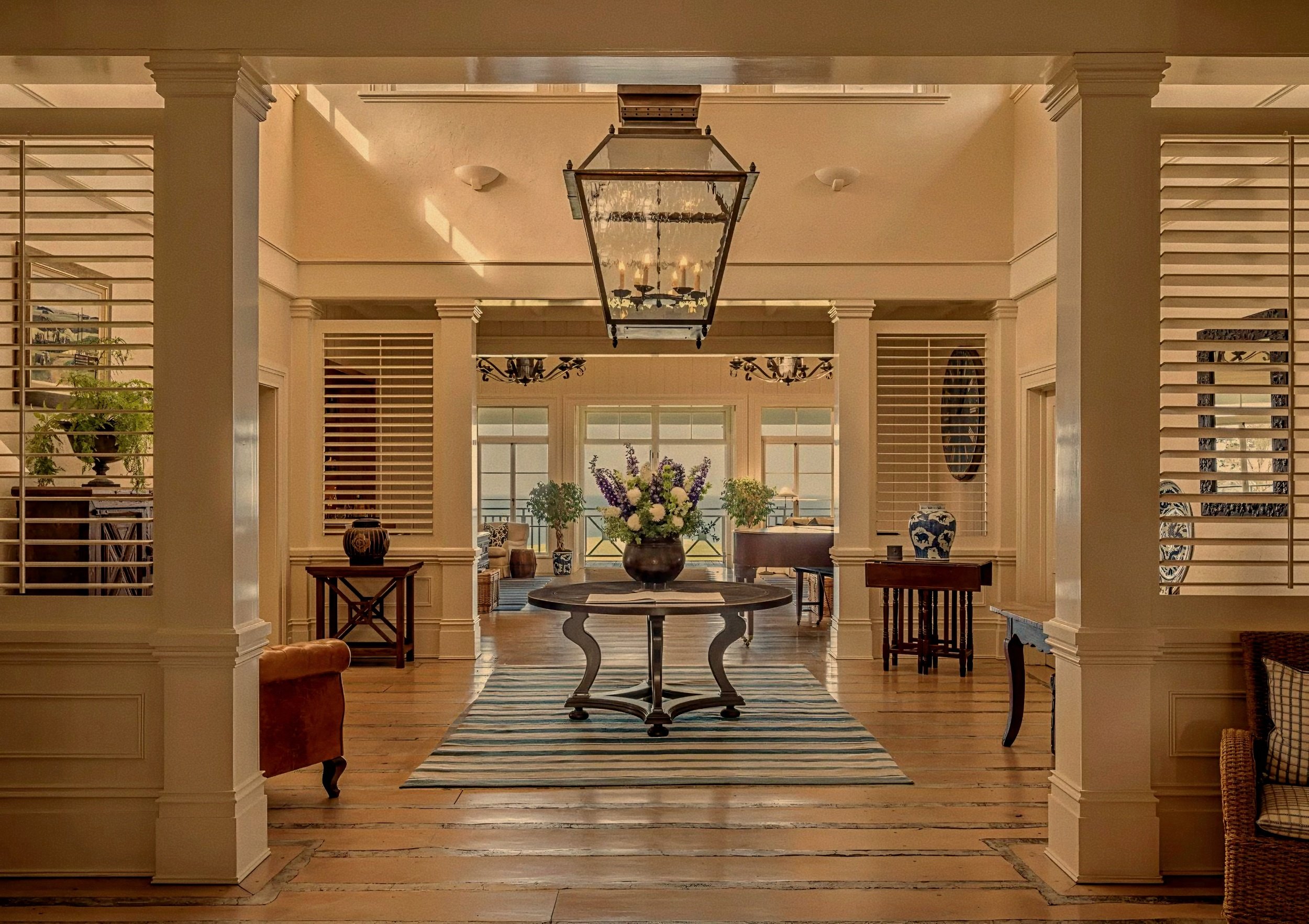 Grand plantation foyer with timber floors designed by Virginia Fisher at Rosewood Kauri Cliffs, New Zealand.