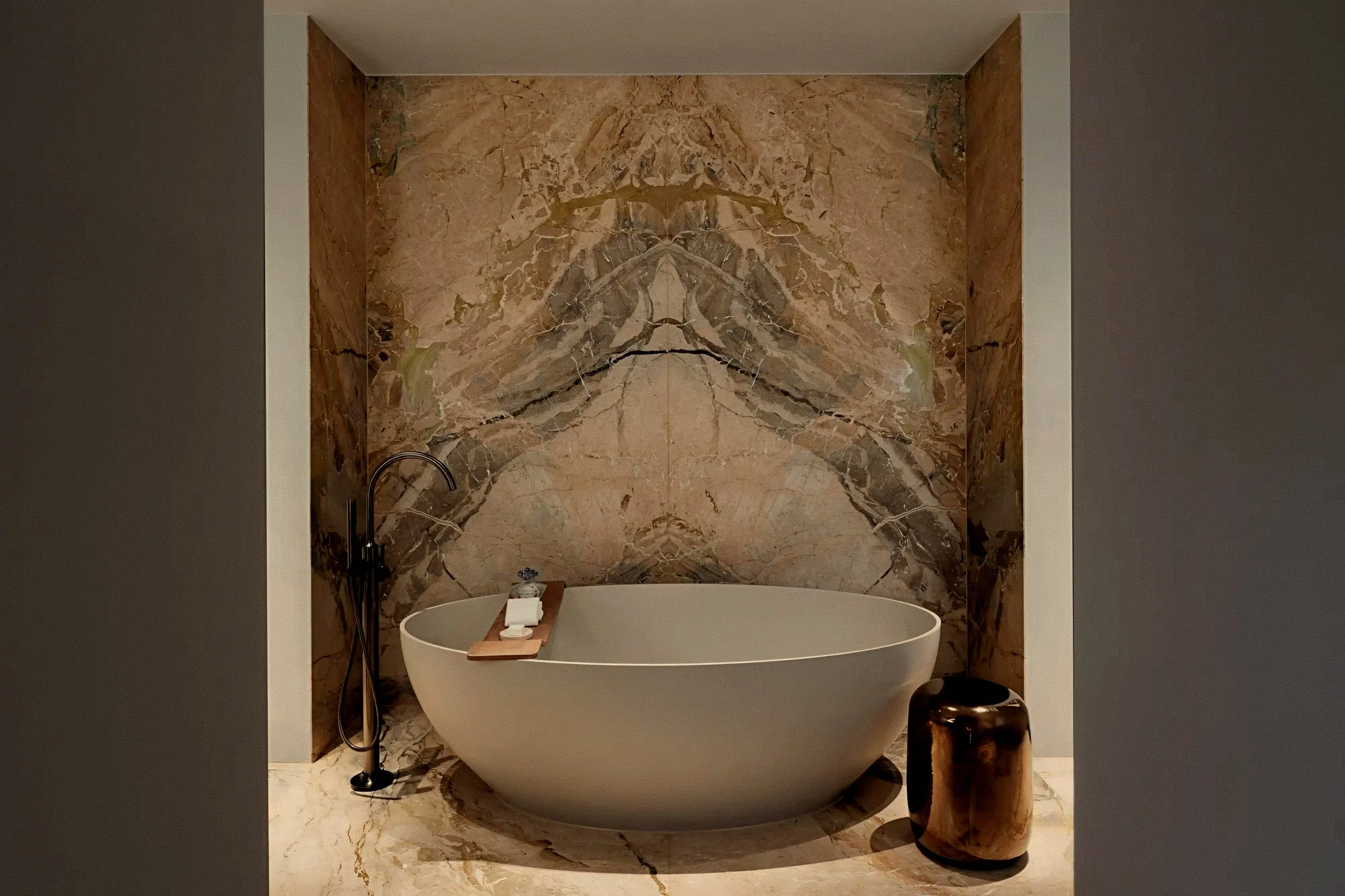 Matte oval soaking tub in marble alcove at Rosewood Amsterdam a luxury hotel in Netherlands.