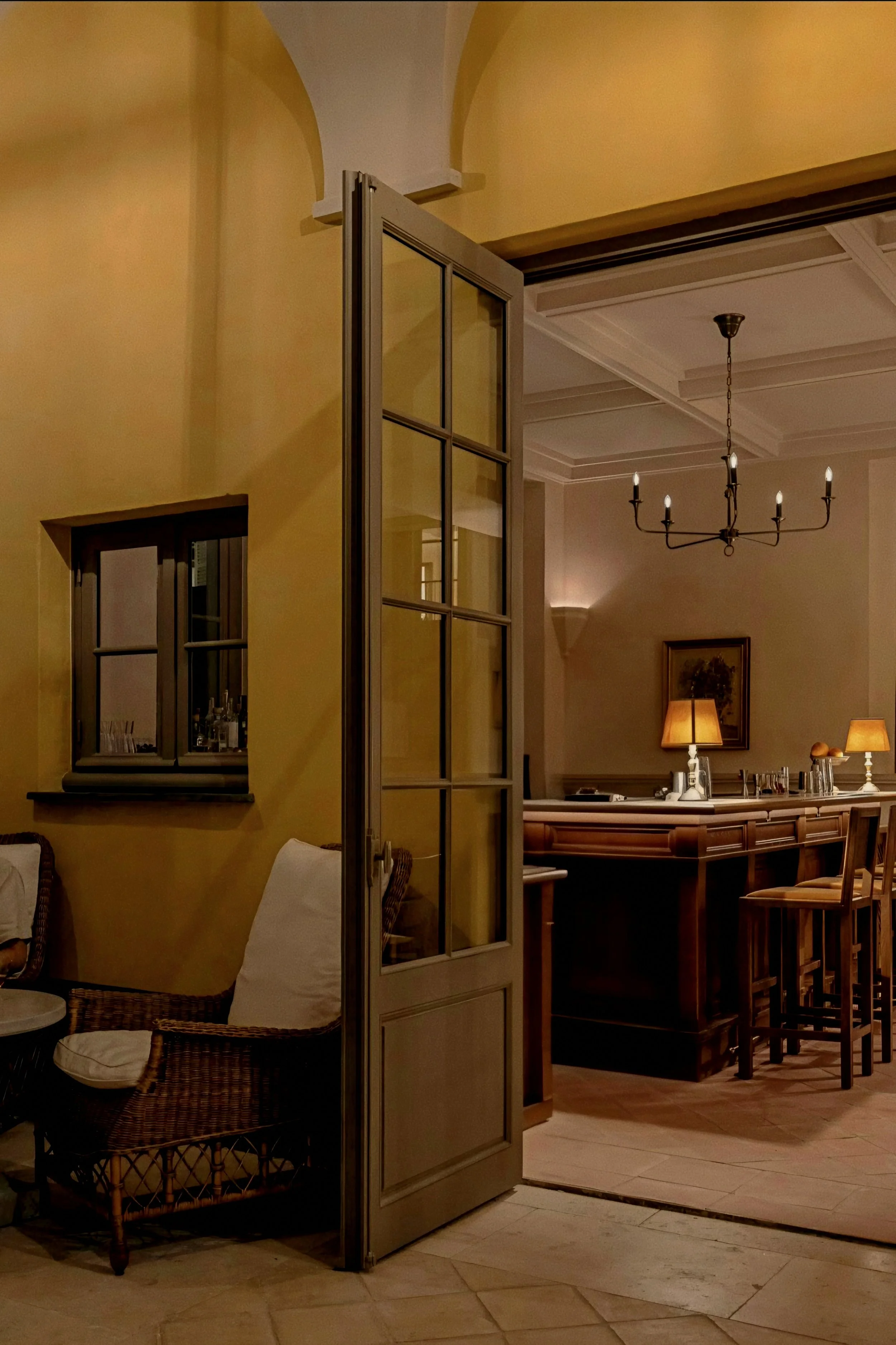 Dark wood counter and wicker armchair at Le Bar at Hôtel du Couvent, a Luxury Collection Hotel, Nice, France.