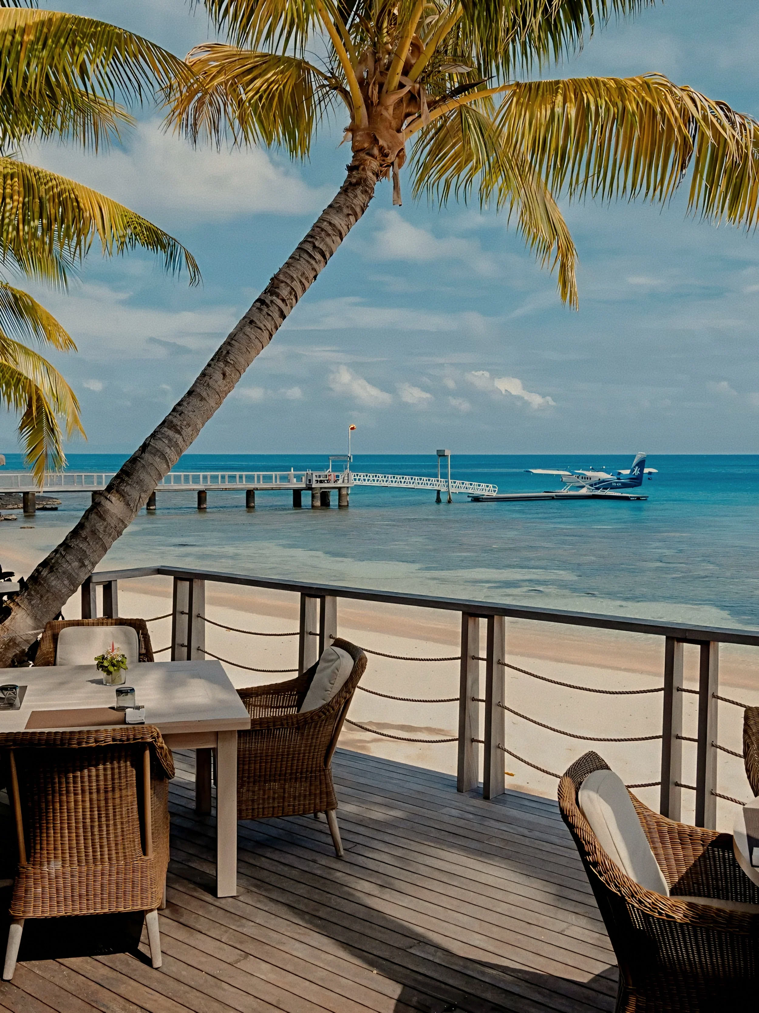 Alfresco beachfront dining deck and private seaplane at Kokomo Private Island in the South Pacific.