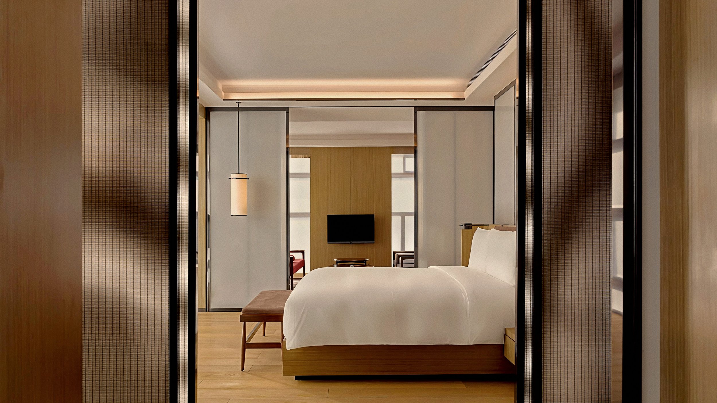 Minimalist suite bedroom with paper lattice screens At The PuXuan Hotel and Spa in Beijing, China.