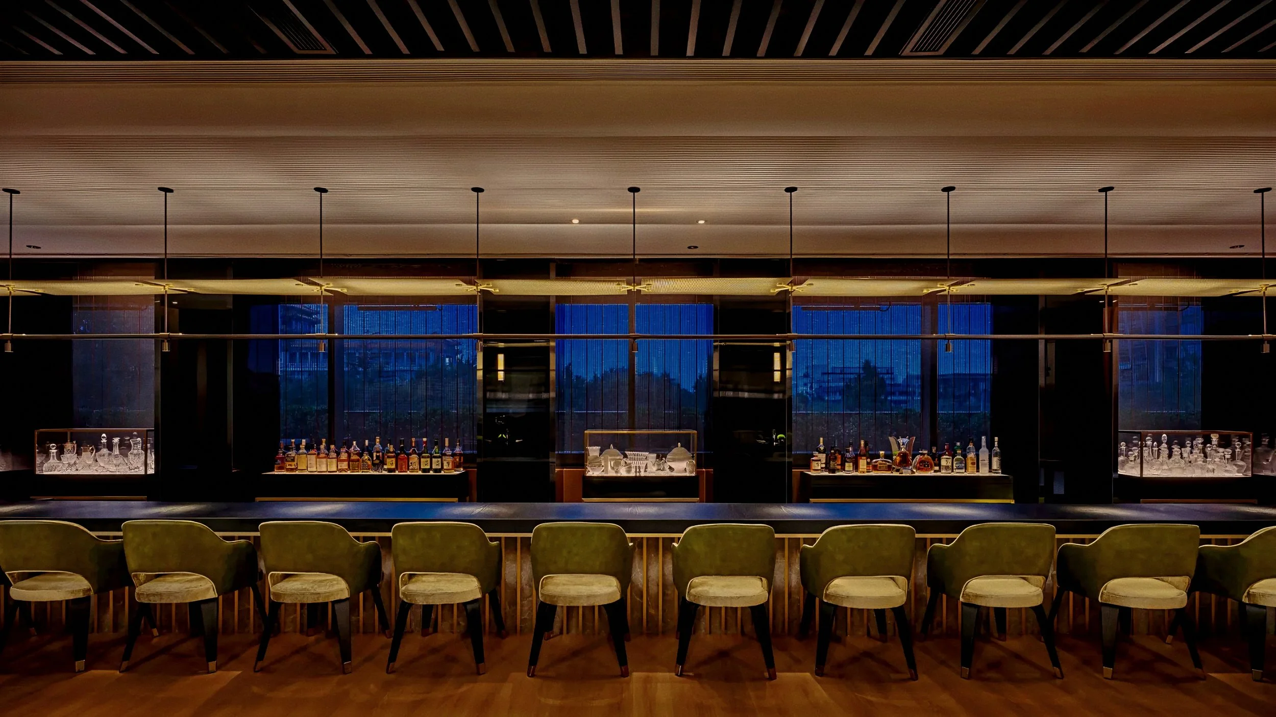 Sleek leather barstools and floating brass canopy At The PuXuan Hotel and Spa in Beijing, China.