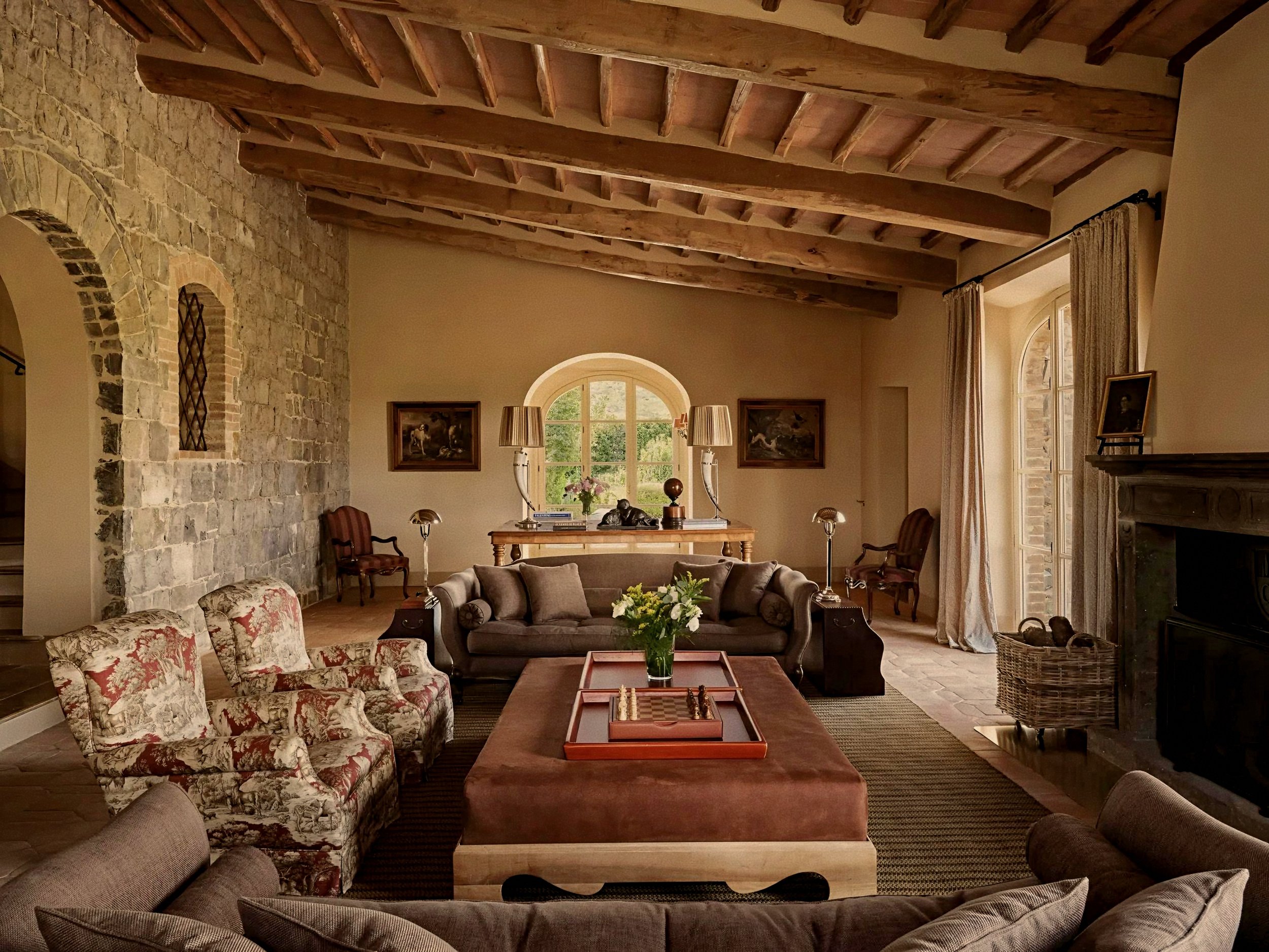 Exposed timber beams and stone hearth salon at Castiglion del Bosco, A Rosewood Hotel, Val d'Orcia, Tuscany, Italy.