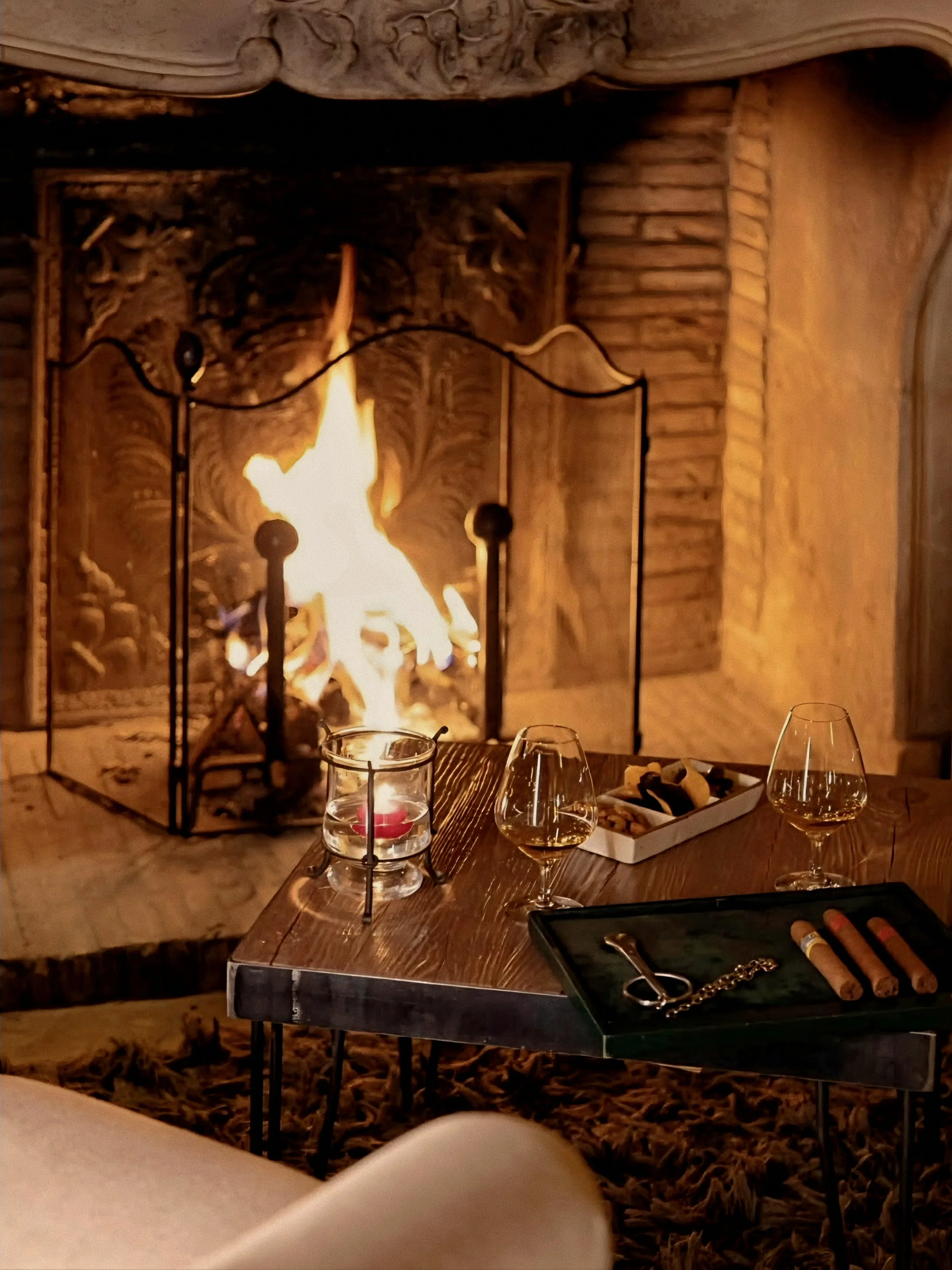 Hearthside fireplace and lounge alcove at Le Chalet d’Adrien Luxury Swiss Alps in Verbier, Valais, Switzerland.