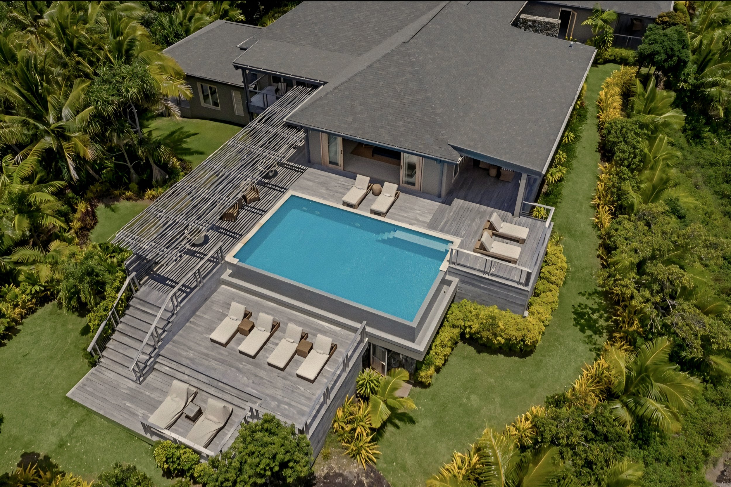 Luxury villa terrace flanked by tiered timber decking and a private pool at Kokomo Private Island, Fiji.