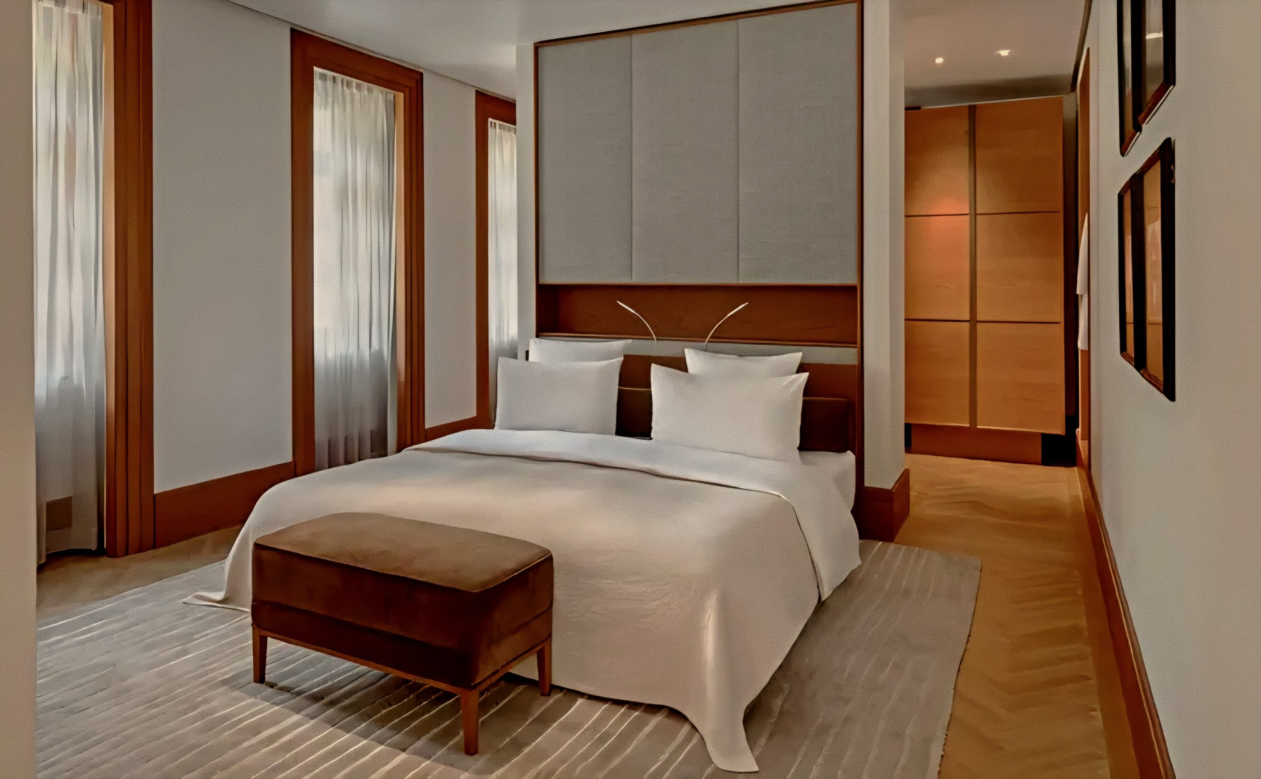 Minimalist suite bed and warm walnut joinery Aman Sveti Stefan Luxury Resort in Montenegro.
